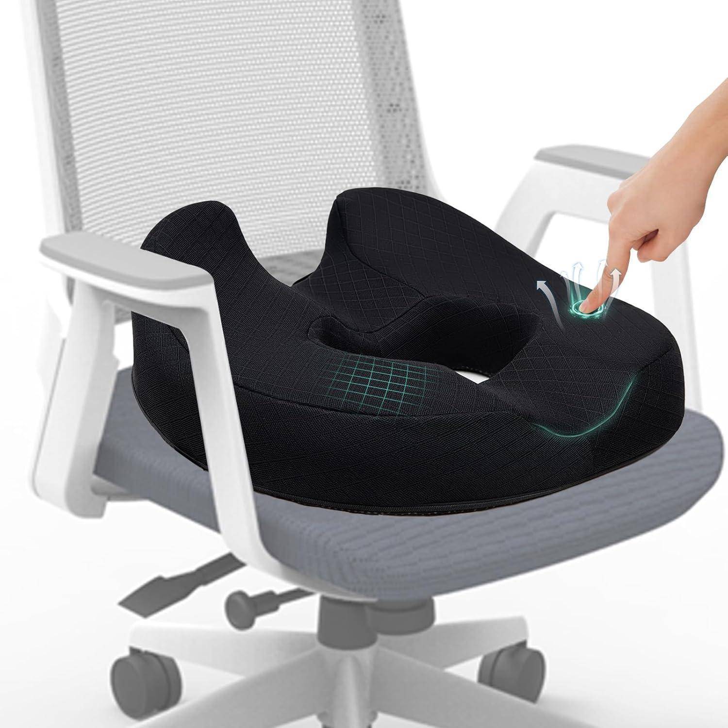 Orthopädisches Sitzkissen auf einem Bürostuhl, mit einer Hand, die es drückt, um seine Weichheit zu zeigen. Entwickelt zur Unterstützung des Steißbeins und für Komfort.