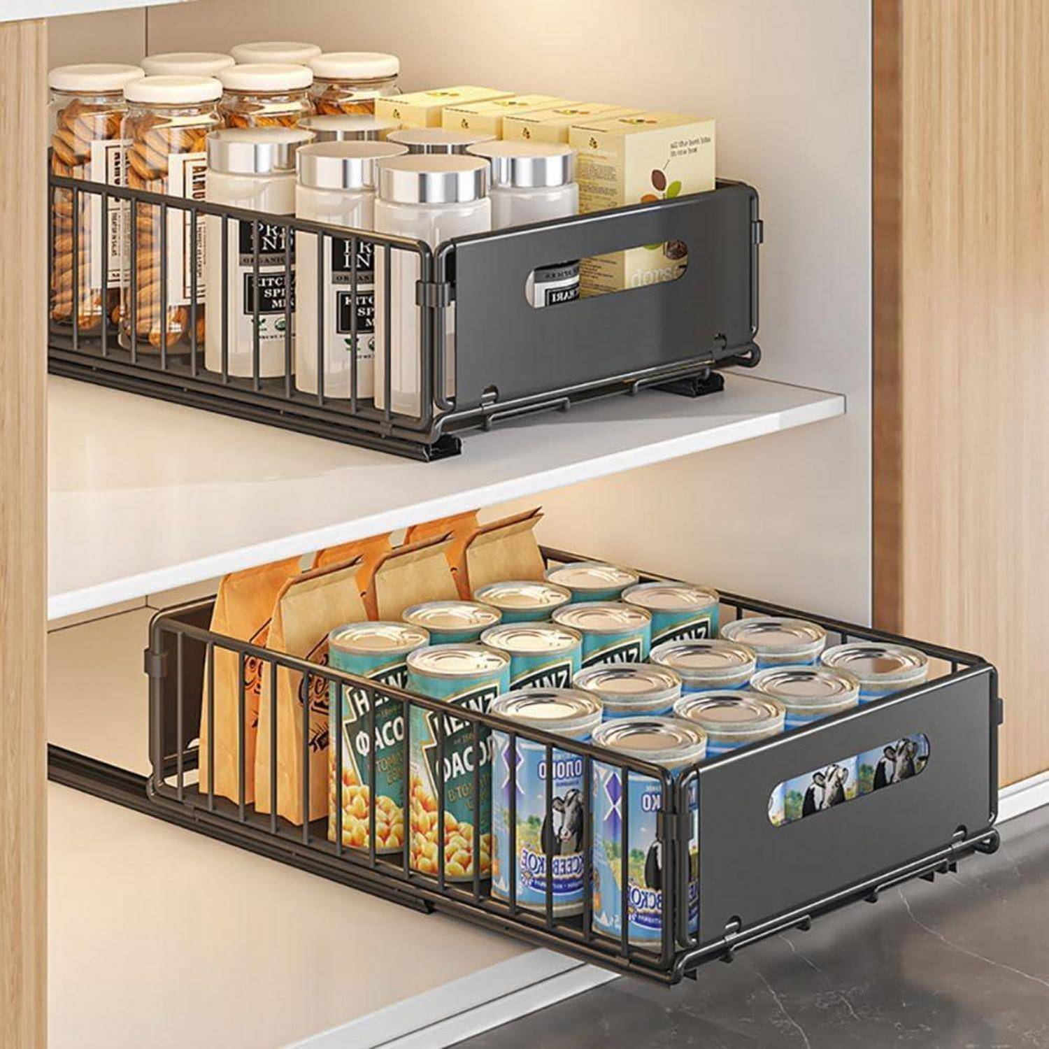 Zwei Regale in einem Holzschrank beherbergen ordentlich angeordnete schwarze Metallkörbe mit Müslikartons, Konservendosen und Gläsern.