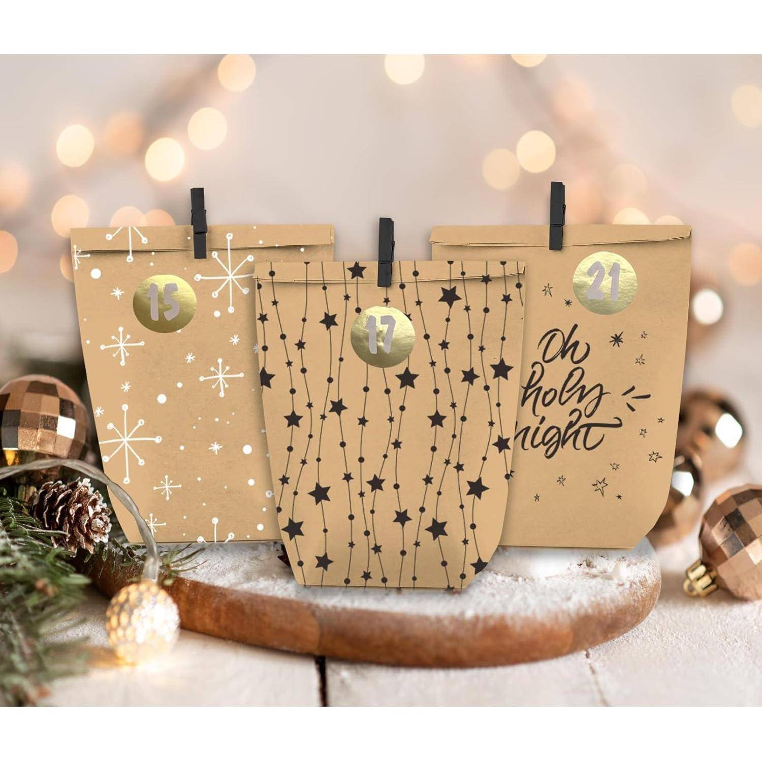 Drei festliche Taschen mit den Etiketten '15', '17' und '21'. Die mittlere Tasche hat Sternen-Muster. Tannenzapfen und Lichter schaffen eine festliche Atmosphäre.