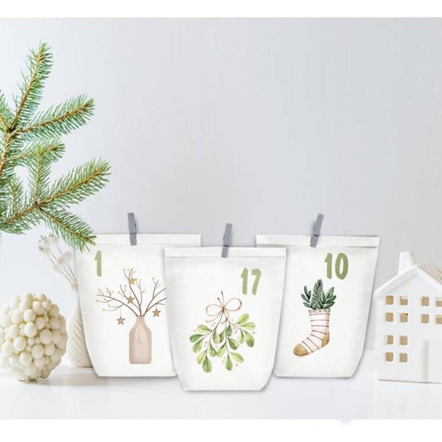 Vier Papiertüten mit nummerierten Designs (1, 17, 10), die winterliche Motive wie Zweige, Mistelzweig und einen Strumpf zeigen, zusammen mit einer Tanne und einer weißen Hausdekoration.
