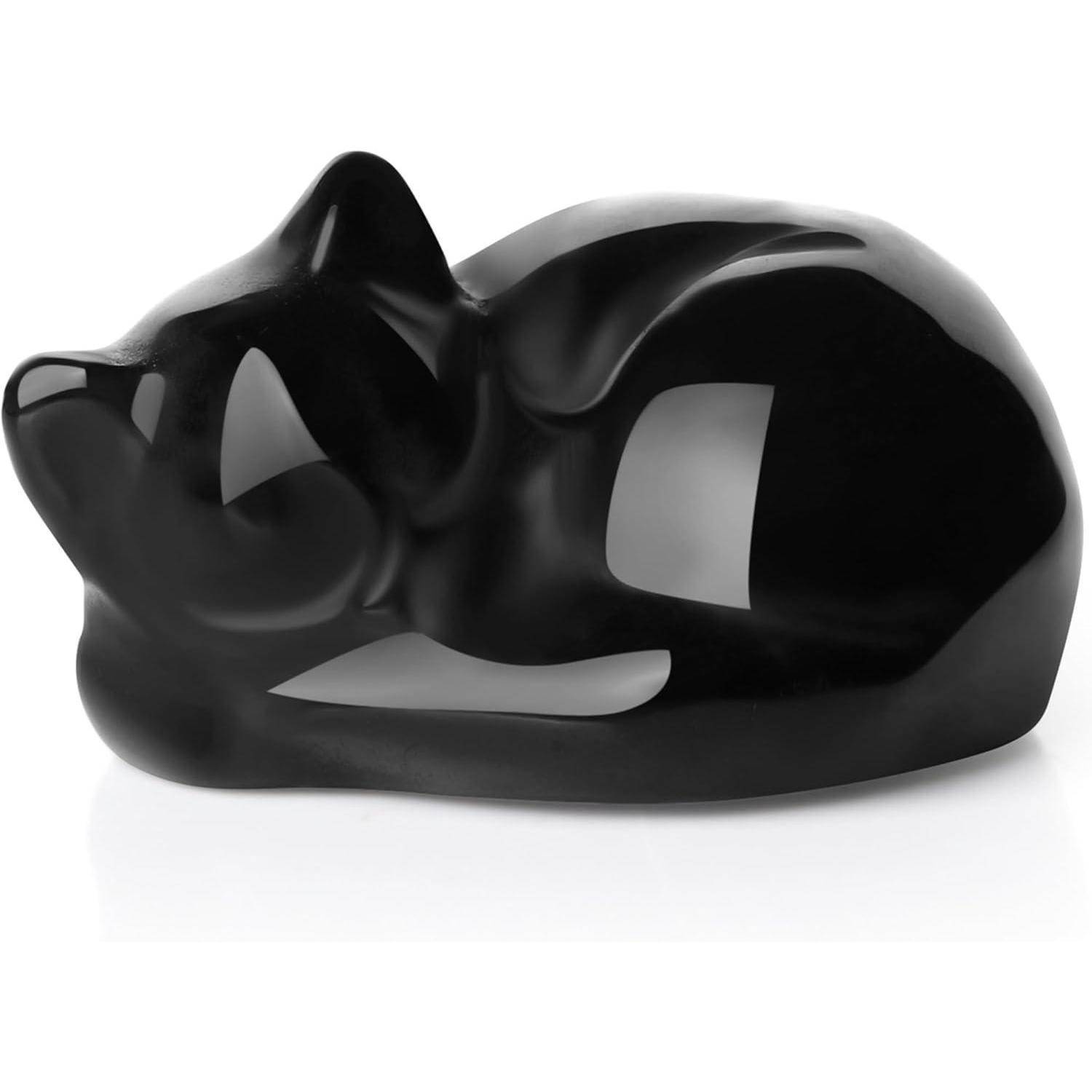 Schwarze Keramik-Skulptur einer zusammengerollten Katze, glatt und minimalistisch im Design, mit glänzender Oberfläche, die eine ruhige, ruhende Haltung zeigt.