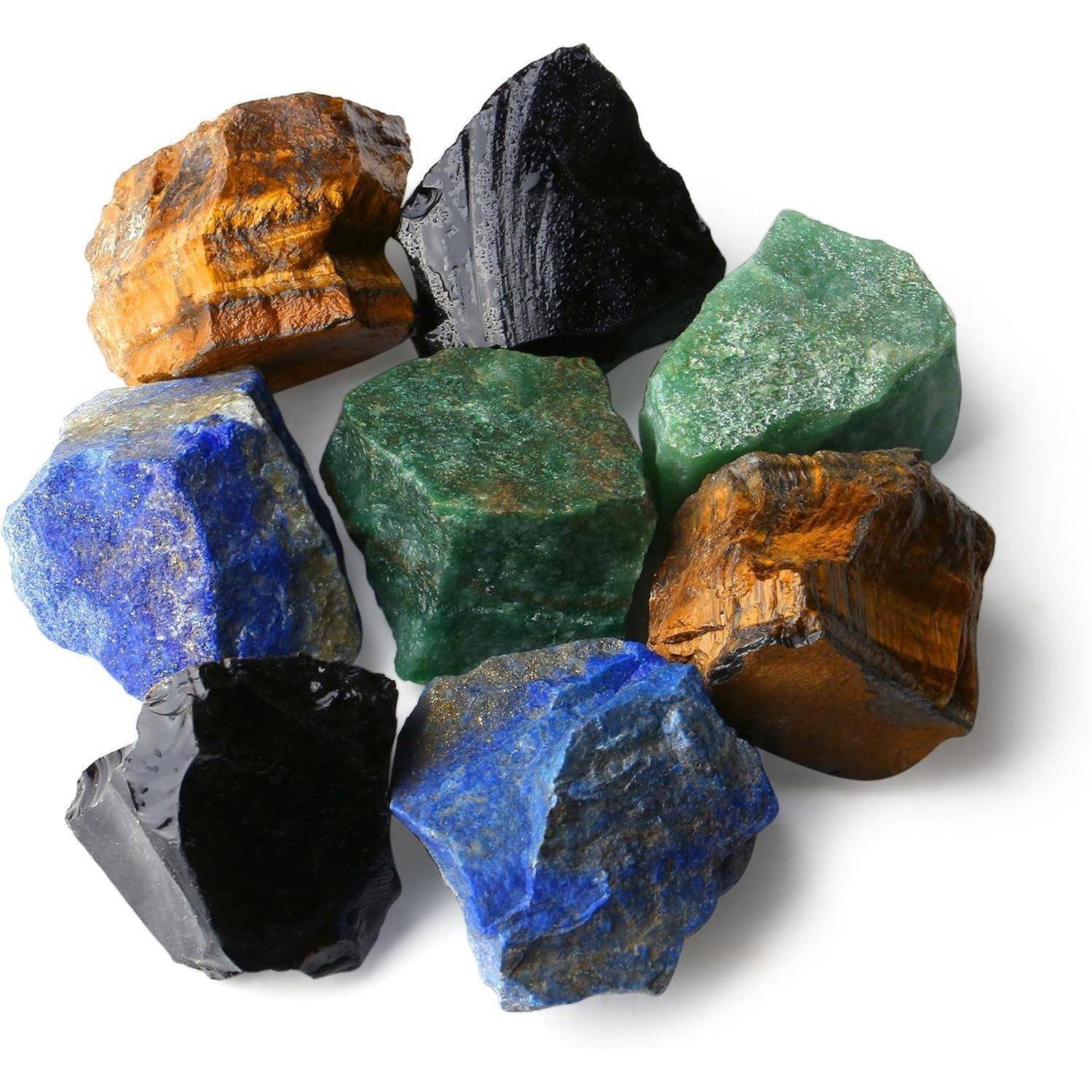 Sieben ungeschliffene Edelsteine in verschiedenen Farben: blau, grün, schwarz und braun. Jeder Stein hat eine einzigartige Textur und Form und zeigt dabei seine natürliche Schönheit.