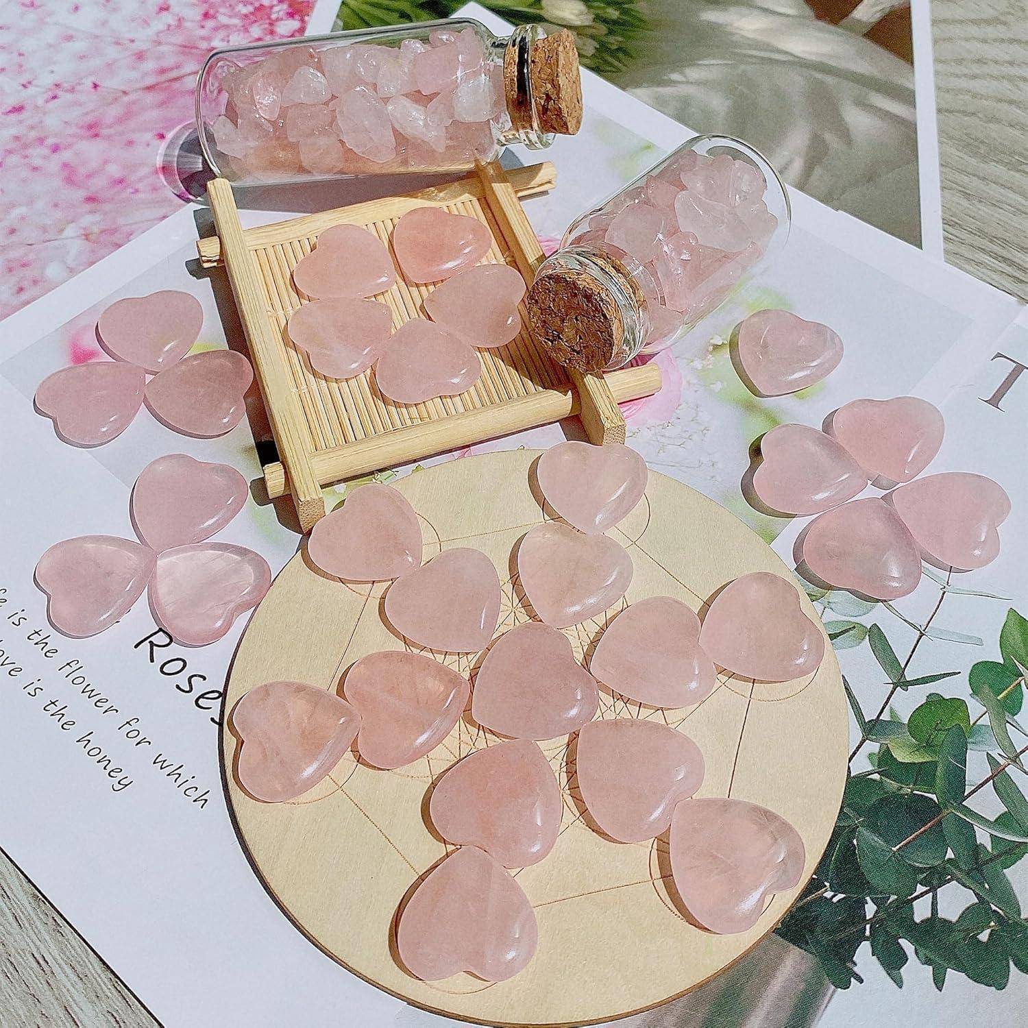 Herzförmige Rosenquarz-Steine sind auf einem kreisförmigen Holzbrett verstreut, wobei einige in Glasflaschen liegen. Eine Pflanze und Papier befinden sich in der Nähe.