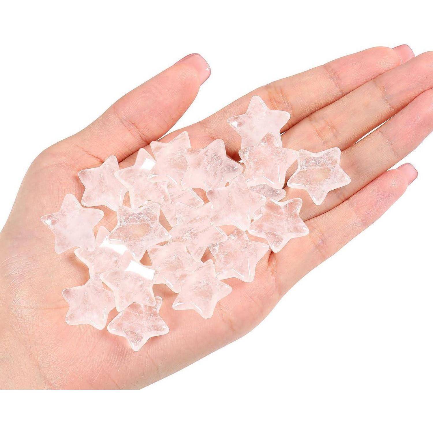 Eine Hand, die mehrere kleine, durchsichtige sternförmige Steine hält.