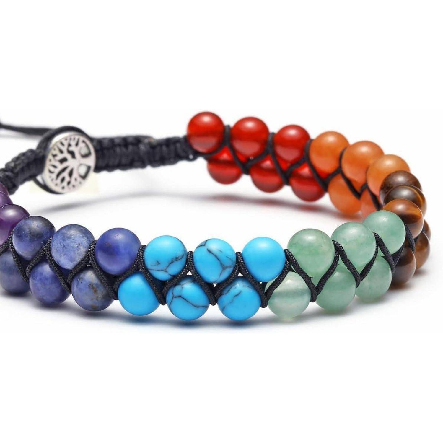 Ein Armband mit einem Farbverlauf aus Halbedelsteinen von Blau bis Rot, mit einer silbernen Baumanhänger-Schließe.