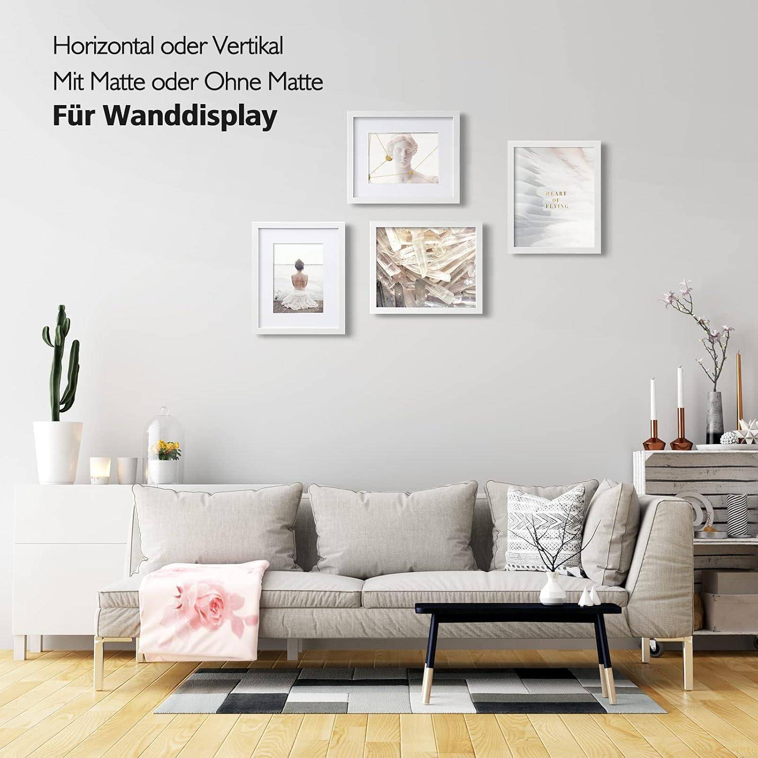 Ein modernes Wohnzimmer mit einem grauen Sofa, einem Couchtisch und Kunstwerken an der Wand. Text auf Deutsch bietet Anzeigeoptionen.