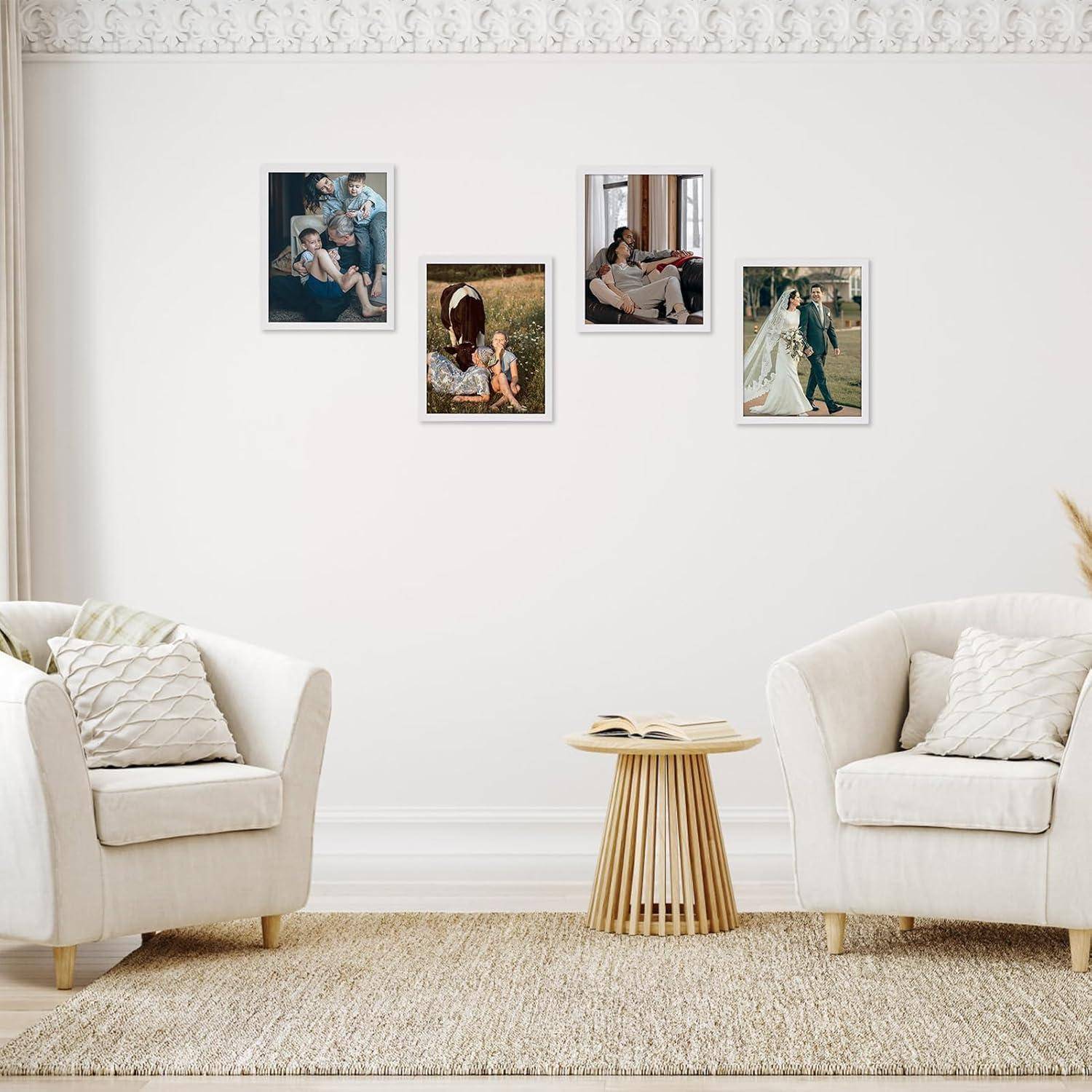Ein Wohnzimmer mit zwei weißen Sofas, einem kleinen Holz-Couchtisch und vier Familienfotos an der Wand. Der Raum hat eine ruhige, gemütliche Atmosphäre.