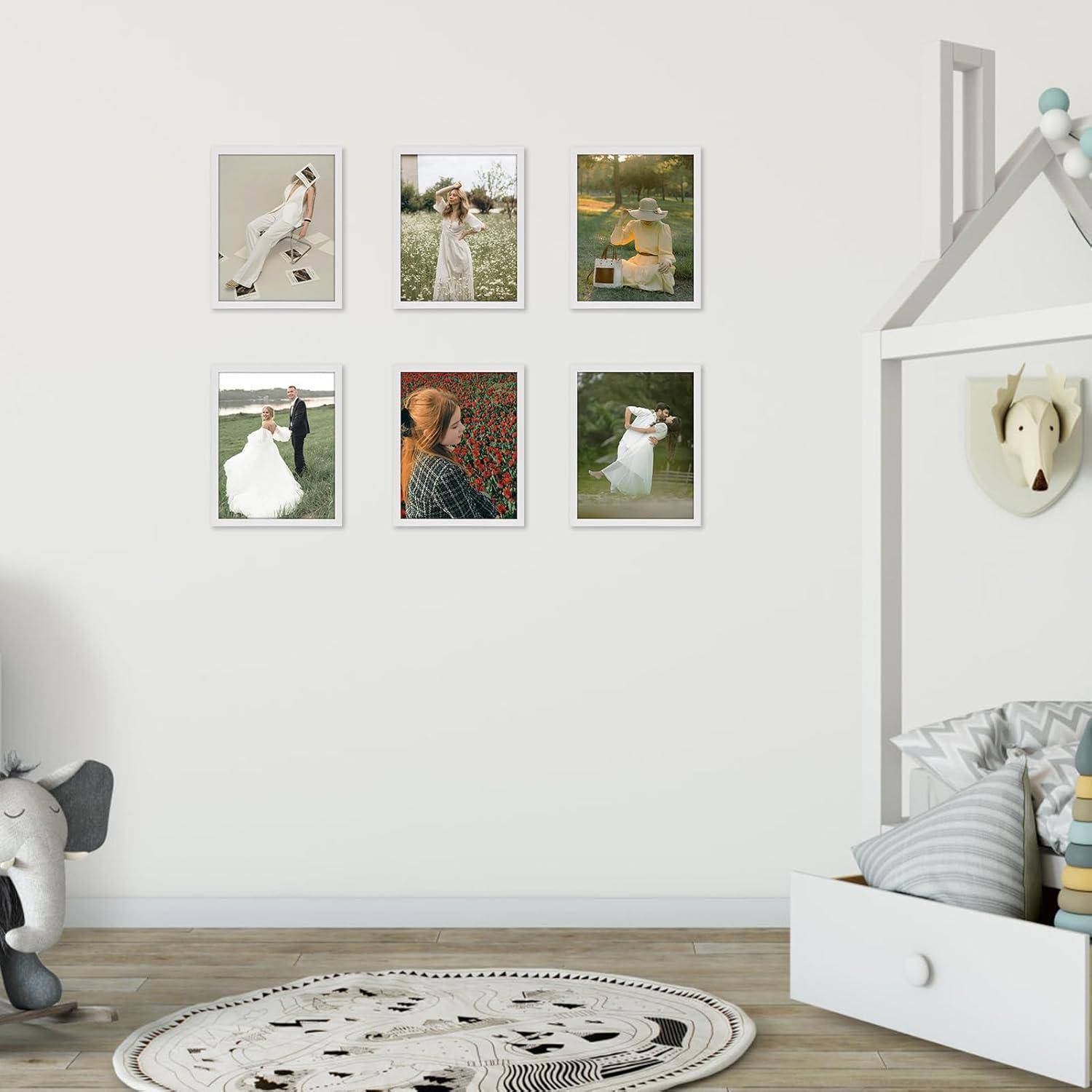 Ein ruhiges Kinderzimmer mit sechs gerahmten Fotos an der Wand, einem Plüschelefanten und einer gemütlichen Leseecke in einem hausbettförmigen Rahmen.