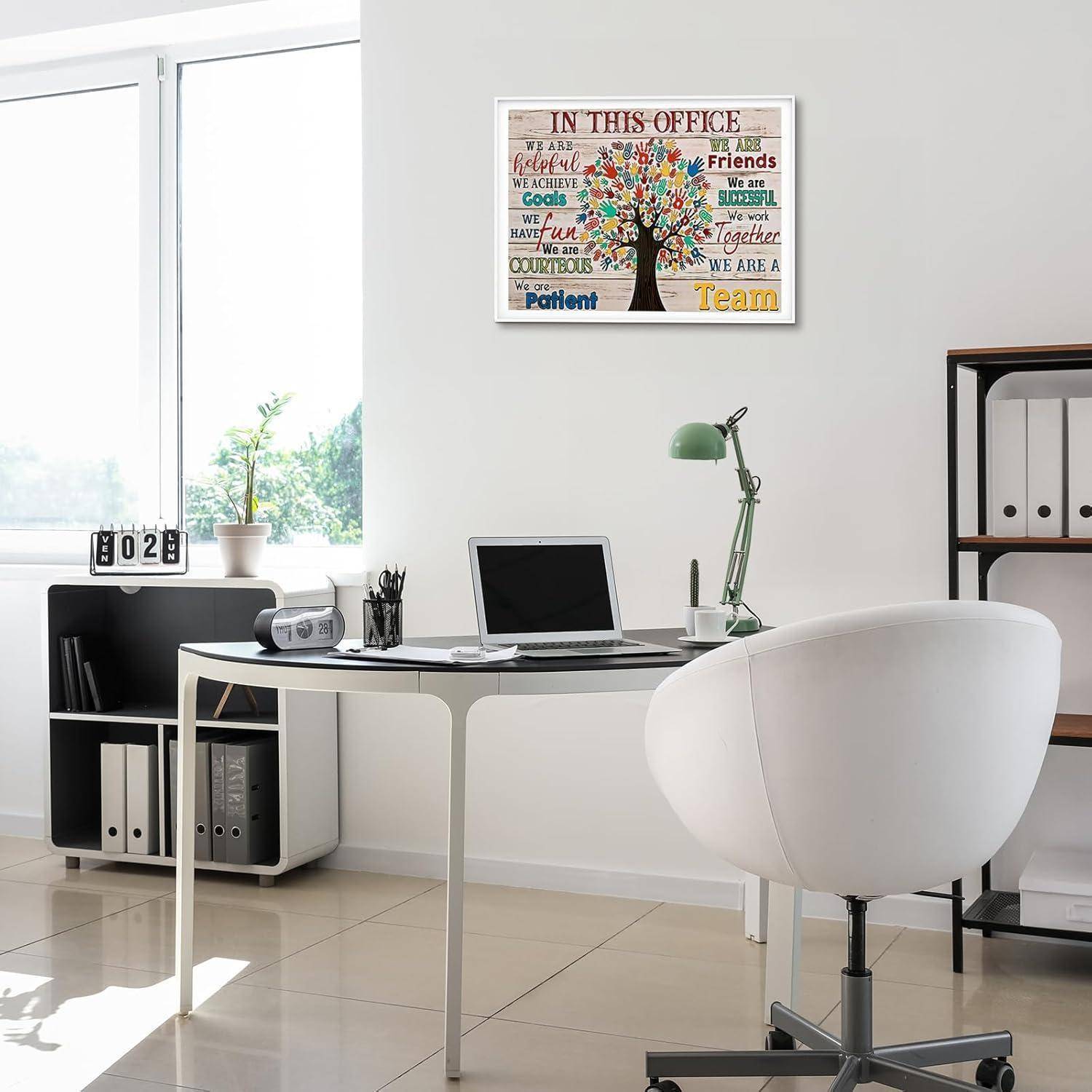 Modernes Büro mit einem Schreibtisch, Laptop, Stuhl und einer Topfpflanze. Wandposter mit motivierenden Worten zum Thema Teamarbeit und Positivität.