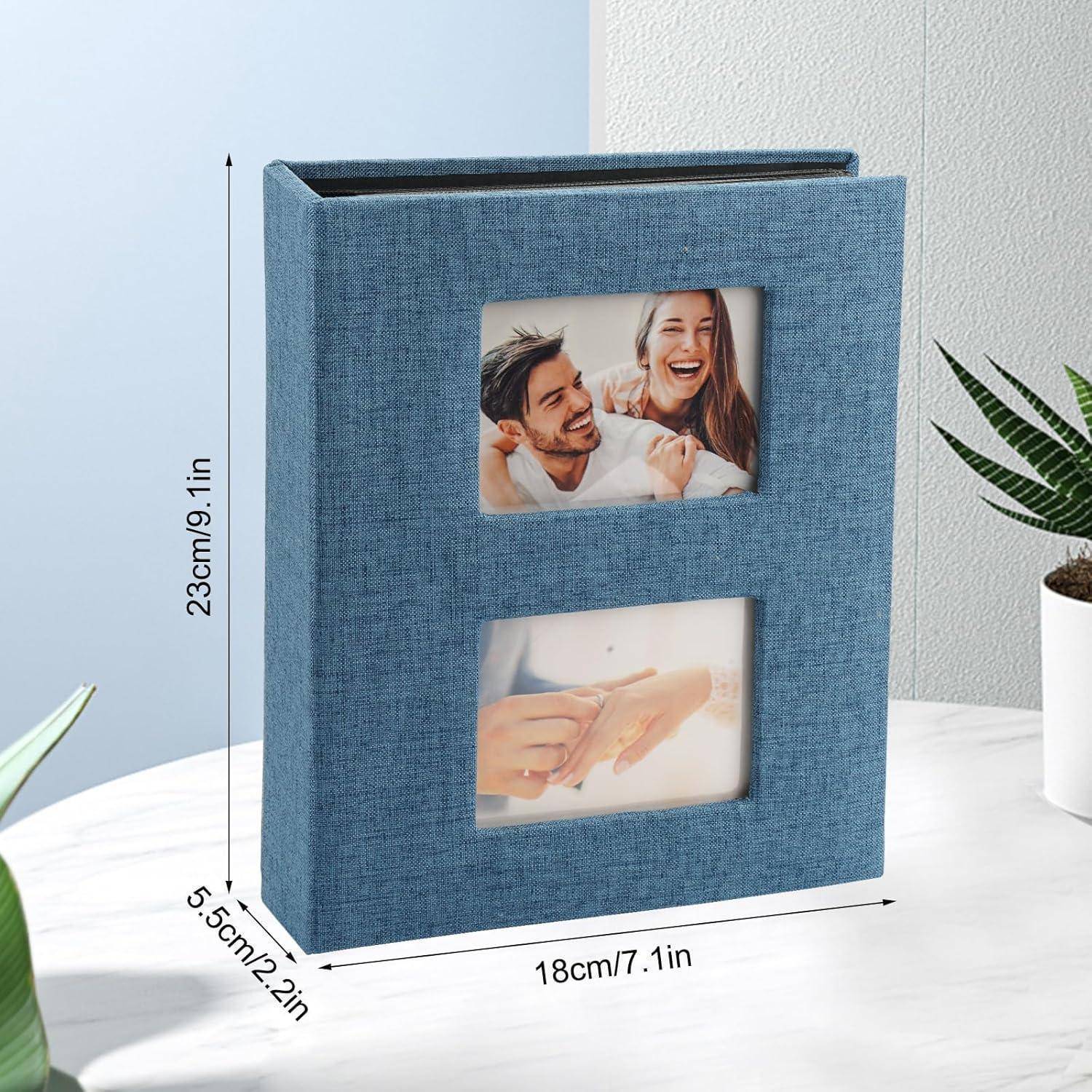 Ein blaues Fotoalbum mit Abmessungen von 23 cm x 18 cm x 5,5 cm verfügt über zwei Bildfenster auf dem Einband, die lächelnde Menschen zeigen, die sich an den Händen halten.