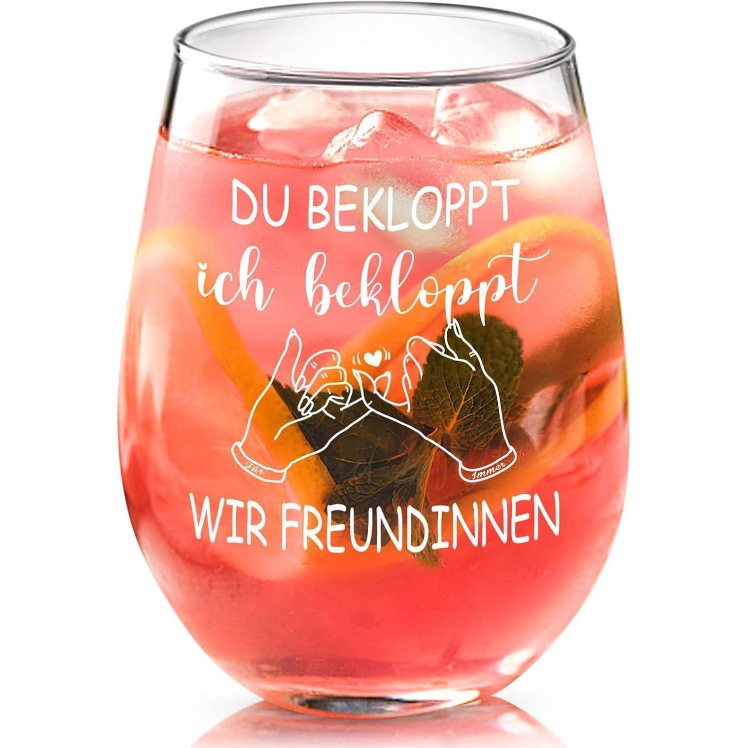 Ein Glas mit rosa Getränk, Eiswürfeln und Orangenscheiben. Text lautet: 'Du bekloppt, ich bekloppt, wir Freundinnen' mit einer Handgeste.