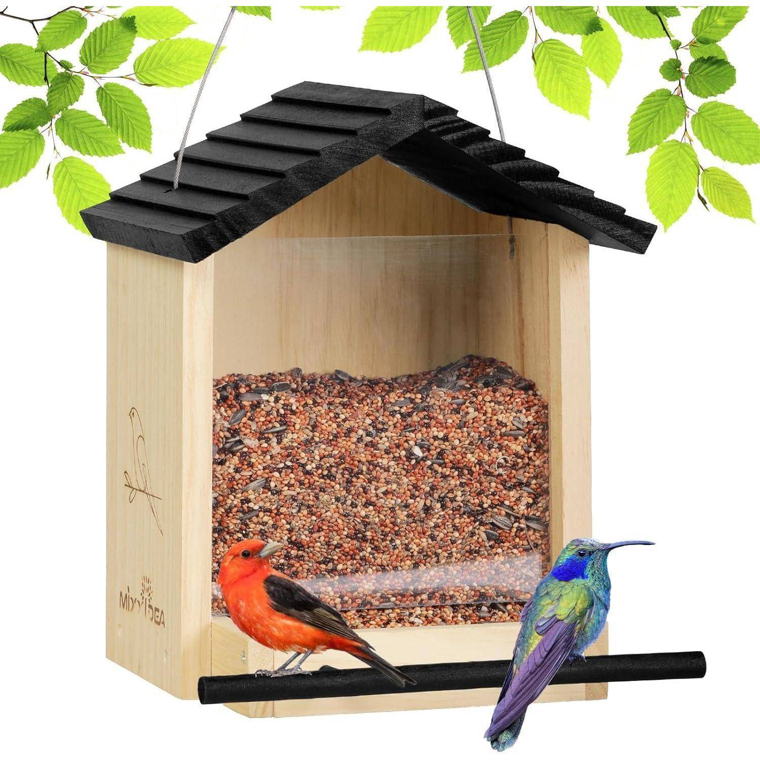 Eine Vogelfutterstelle mit gemischten Samen im Inneren, die einen roten und einen mehrfarbigen Vogel zeigt, die auf einer schwarzen Stange sitzen, umgeben von grünen Blättern.