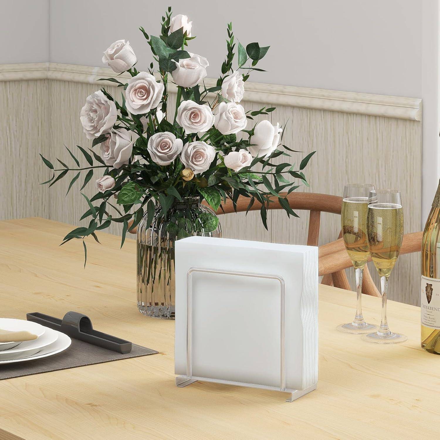 Ein Esstisch mit einer Vase voller weißer Rosen, einer gefalteten Serviette und zwei Champagnerflöten, aufgestellt in einer sanft beleuchteten Ecke des Speisezimmers.