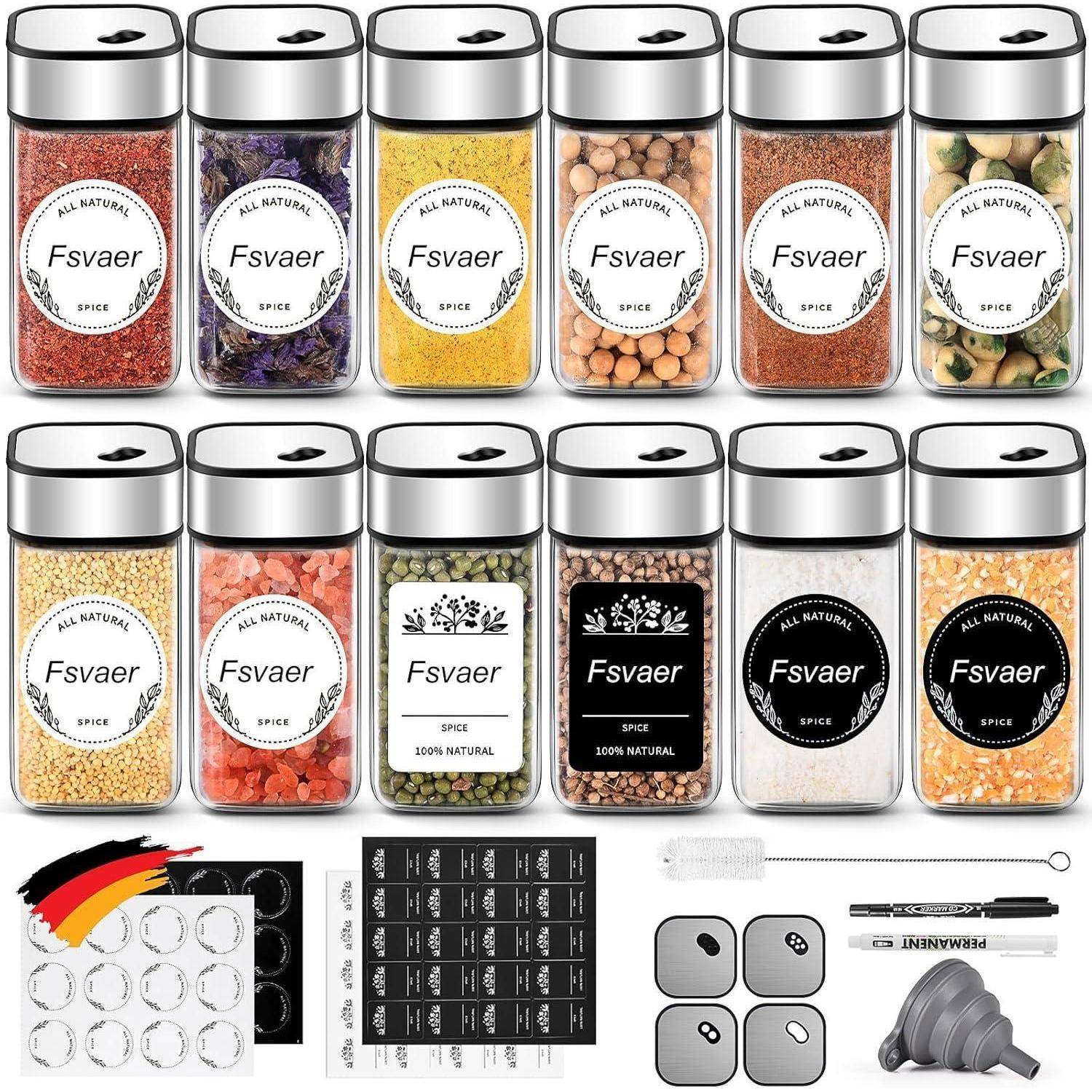 Set aus Gewürzgläsern mit schwarzen Deckeln, beschriftet mit 'FsvAer', verschiedene Gewürze in Gläsern, leere und vorgedruckte Etiketten, Messlöffel und Trichter enthalten.