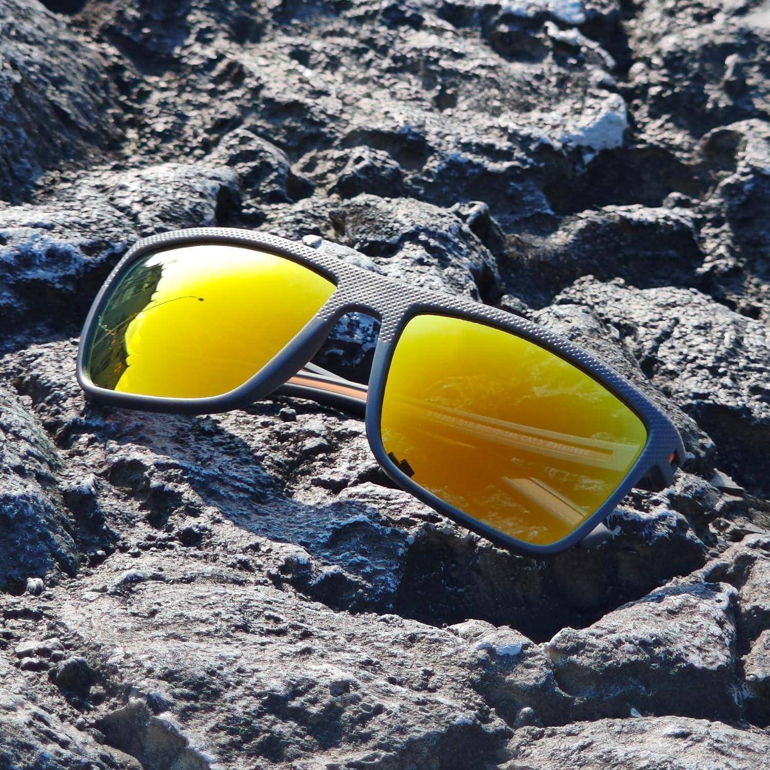 Sonnenbrille mit reflektierenden gelben Gläsern, die auf einer strukturierten schwarzen Felsoberfläche in Sonnenlicht liegen.