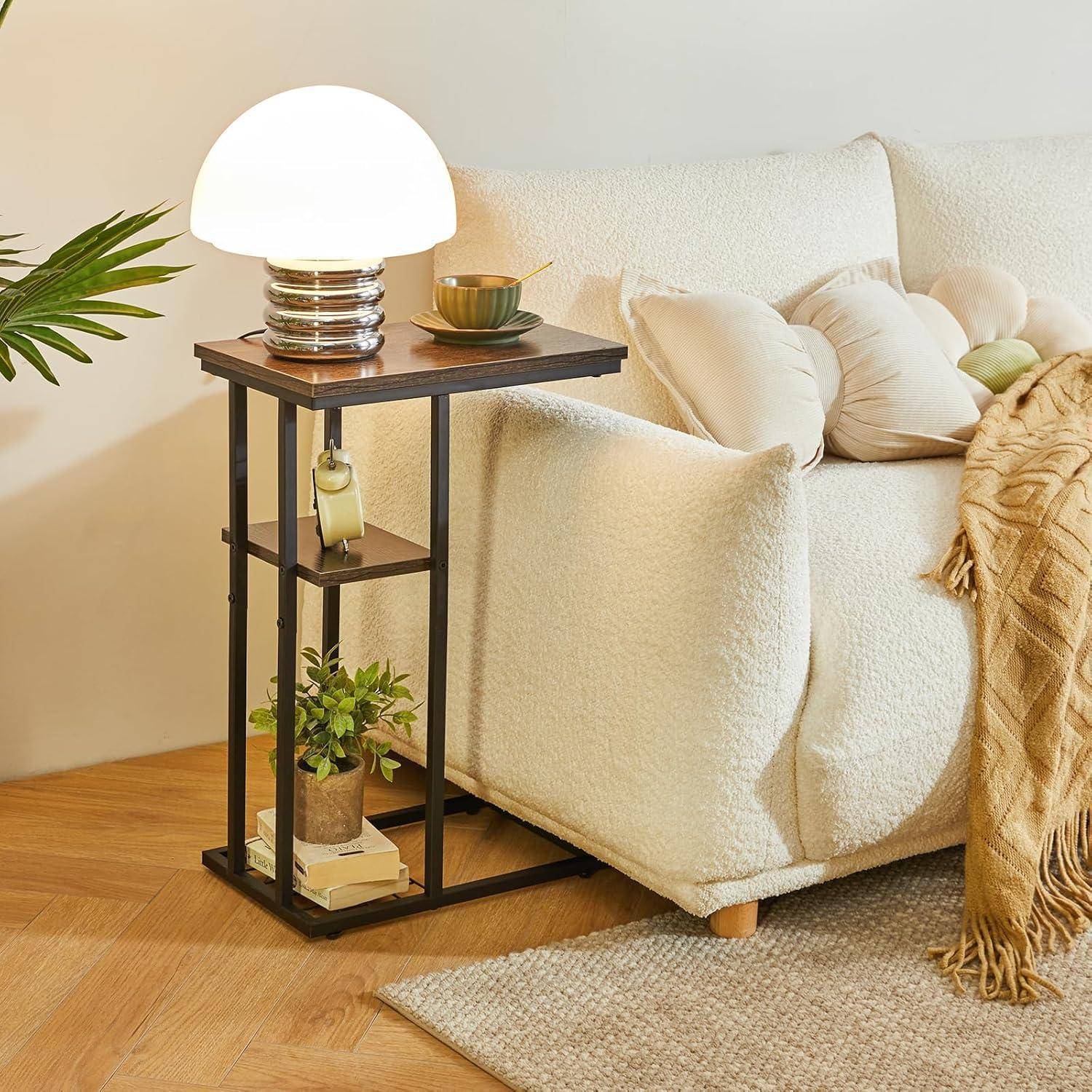 Eine gemütliche Ecke im Wohnzimmer mit einem beigen Sessel, einem Kissen und einem nahegelegenen Holzbeistelltisch. Auf dem Tisch steht eine leuchtende Lampe und kleine Pflanzen.