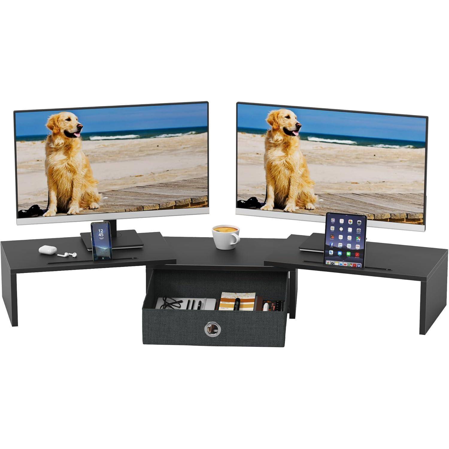 Ein schwarzer Eckschreibtisch mit zwei Monitoren, die eine Strand-Szene mit einem Hund zeigen. Ein Telefon, ein Tablet und eine Tasse stehen auf dem Schreibtisch. Darunter befindet sich eine Schublade.