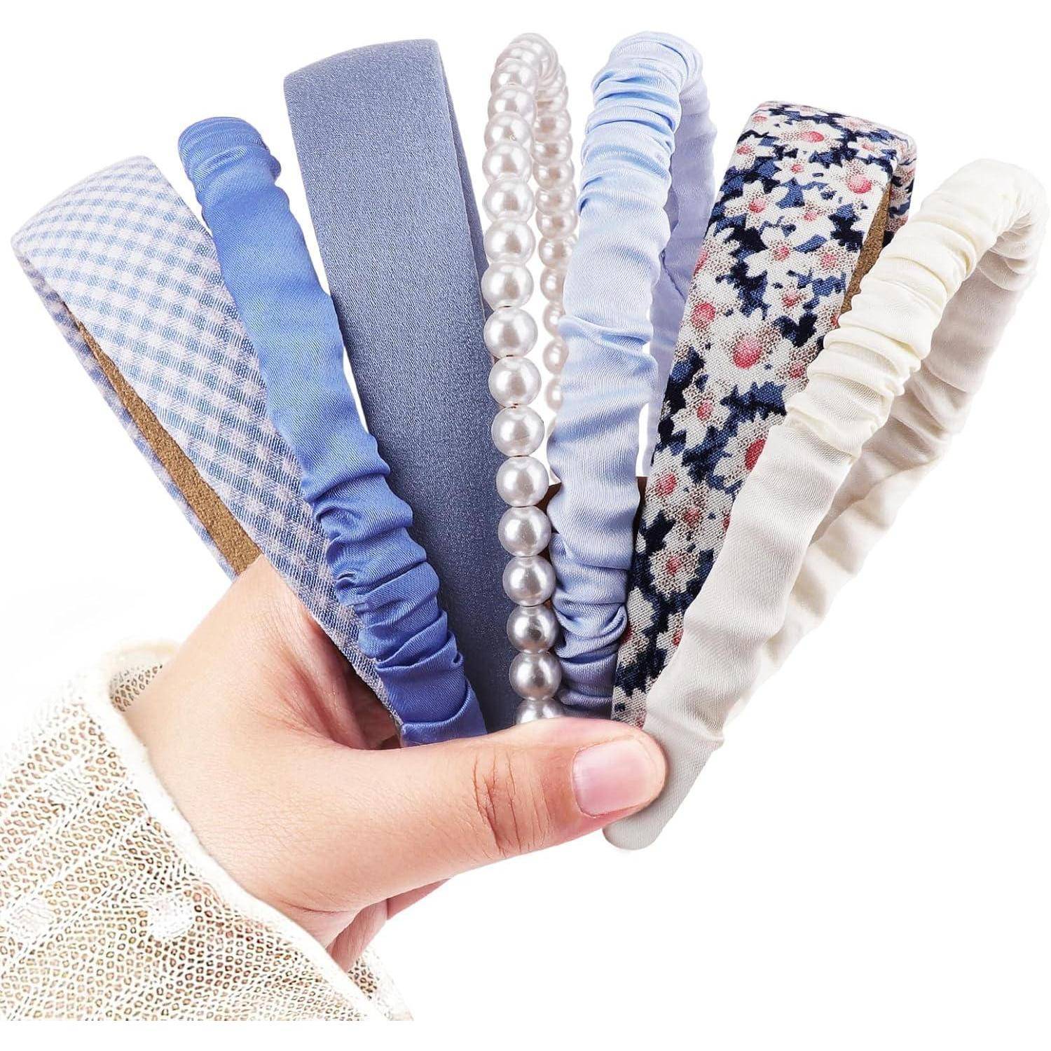 Eine Hand hält sechs verschiedene Haarreife mit Mustern wie Vichy-Karo, Perlen, Blumenmotiven und Satin in Blau- und Beigetönen.