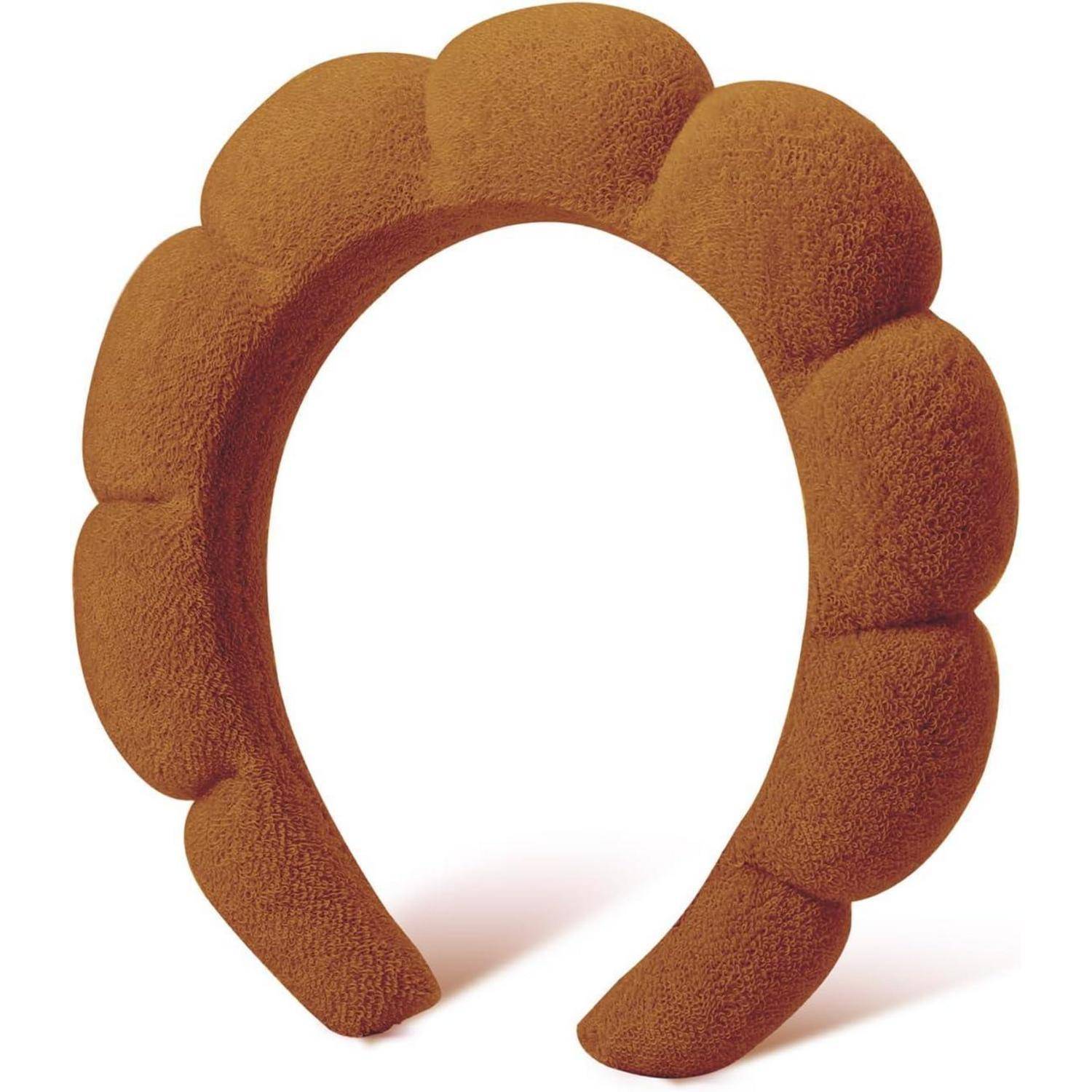 Ein strukturiertes, muschelförmig gemustertes braunes Haarband mit breitem, gepolstertem Design.
