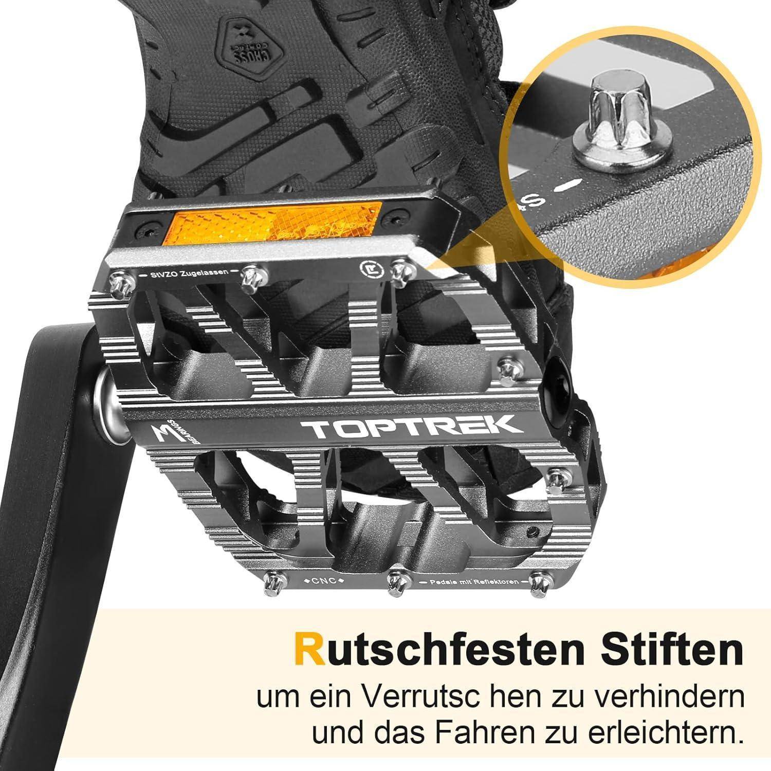 Eine Nahaufnahme eines Fahrradpedals mit der Markenbezeichnung ‚TOPTREK', versehen mit reflektierenden Akzenten und rutschfesten Pins. Der deutsche Text betont die Sicherheitsmerkmale.