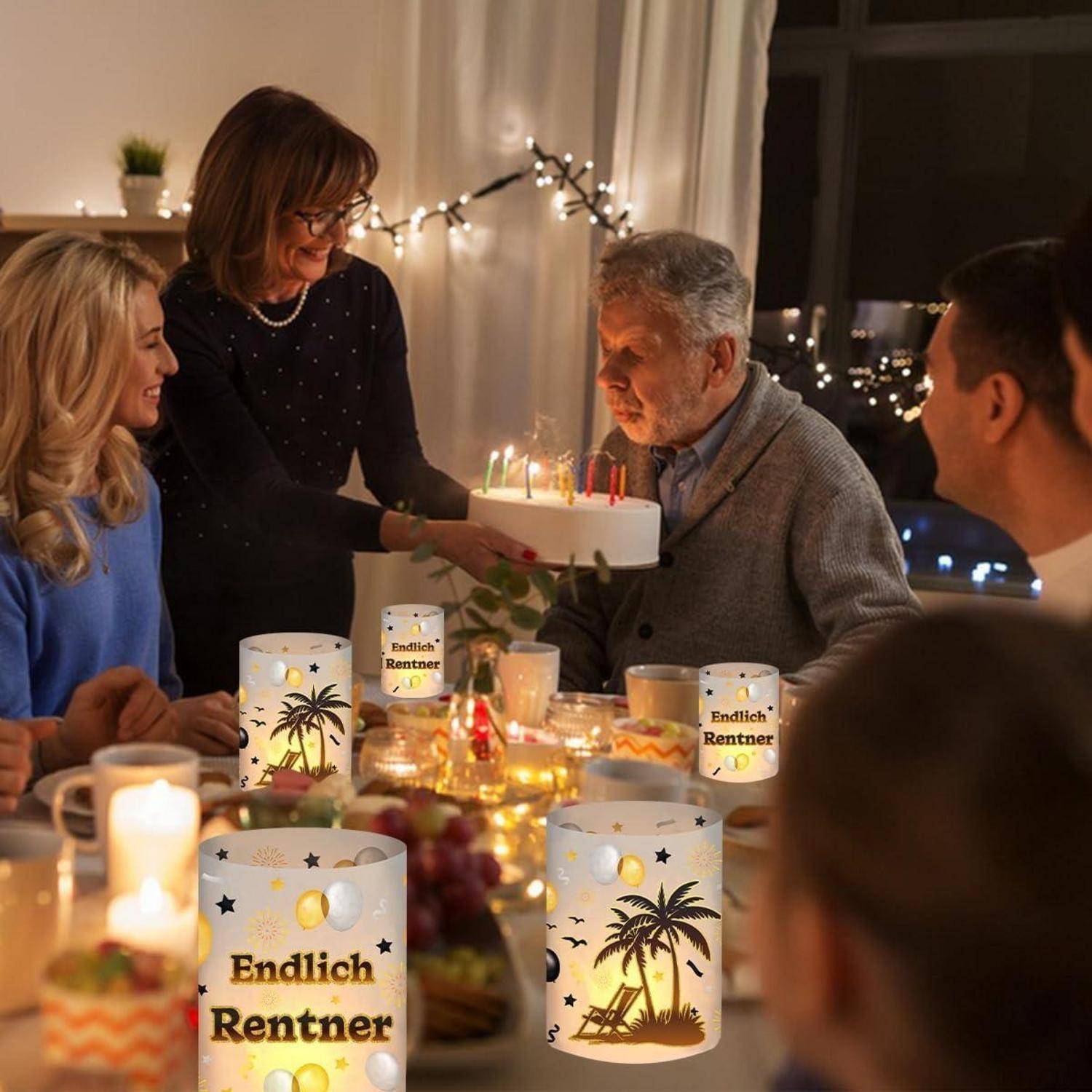 Eine Familie versammelt sich um einen Tisch, um einen besonderen Anlass zu feiern. Eine Frau präsentiert einem älteren Mann eine Torte, während festliche Kerzen in der Nähe angezündet sind.
