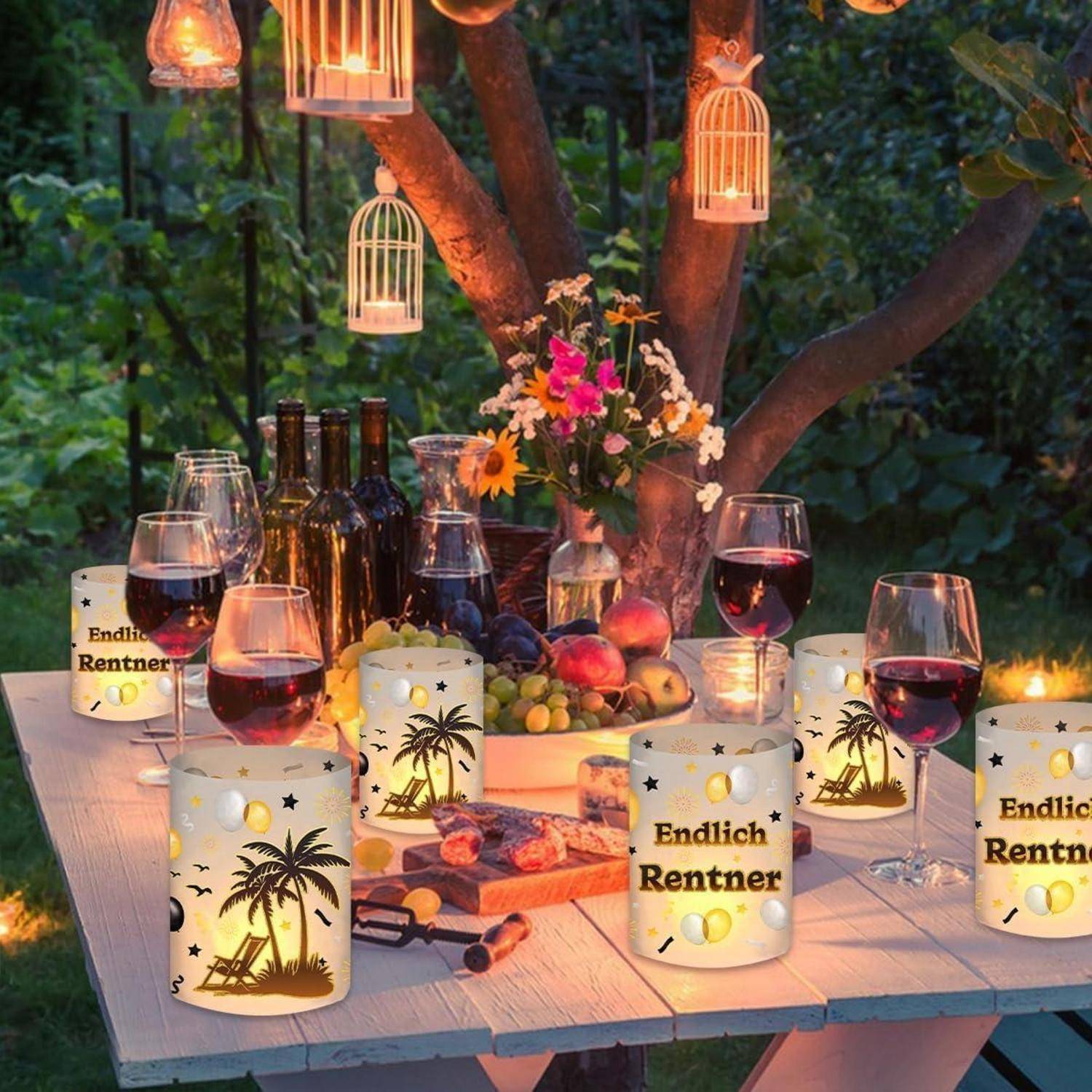 Gedeckter Tisch unter einem Baum für ein Treffen im Freien mit Weingläsern, Flaschen und Snacks. Dekorative Laternen werfen ein warmes Leuchten.