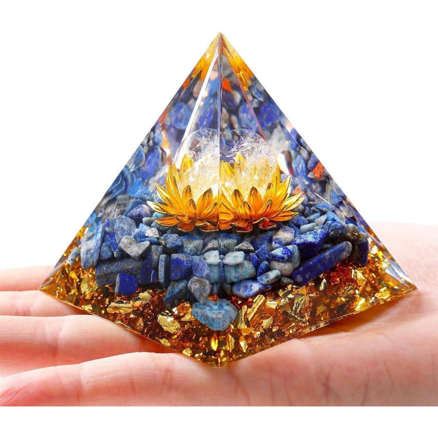 Eine Hand, die ein pyramidenförmiges Objekt hält, das aus blauen und goldenen Steinen besteht, mit einer kleinen goldenen Lotusblume in seinem Zentrum.