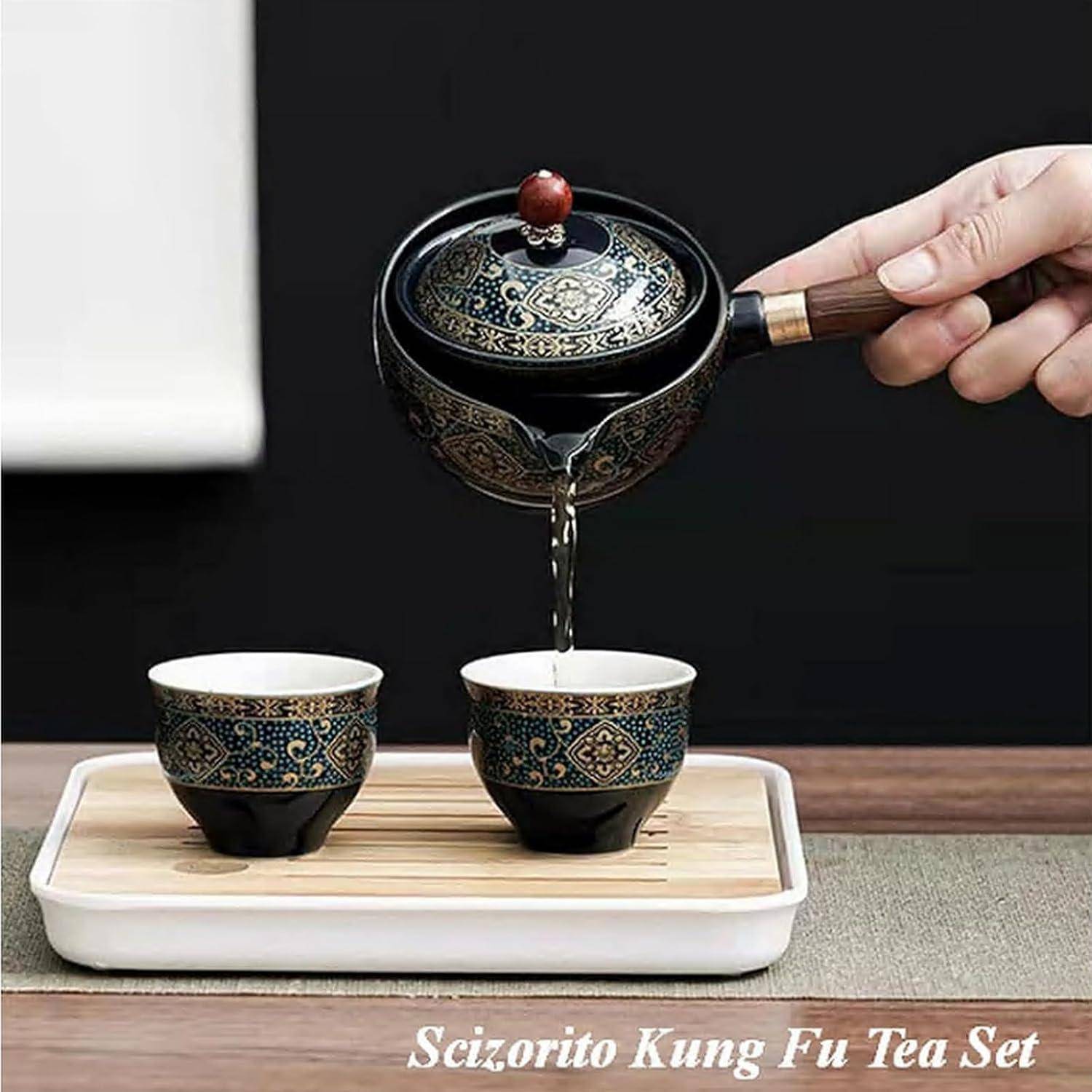 Eine Hand gießt Tee aus einer gemusterten Teekanne in zwei kunstvoll gestaltete Teekups auf einem Tablett, beschriftet mit 'Scizorito Kung Fu Tee-Set'.