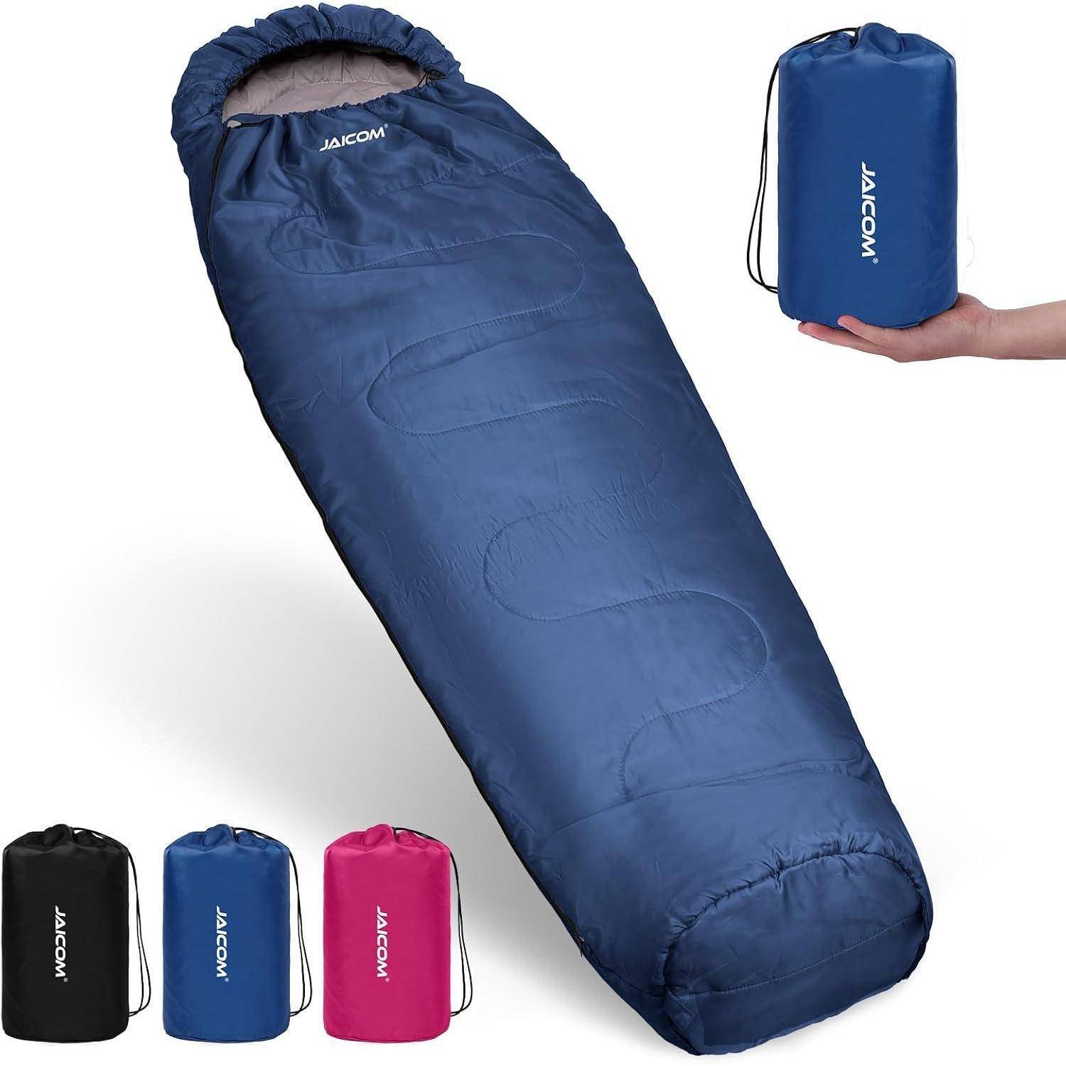 Eine blaue Schlafsack wird präsentiert. Eine Hand hält dessen kompakte Aufbewahrungstasche, die blau ist. Zusätzliche Aufbewahrungstaschen in Schwarz, Rosa und Blau werden gezeigt.