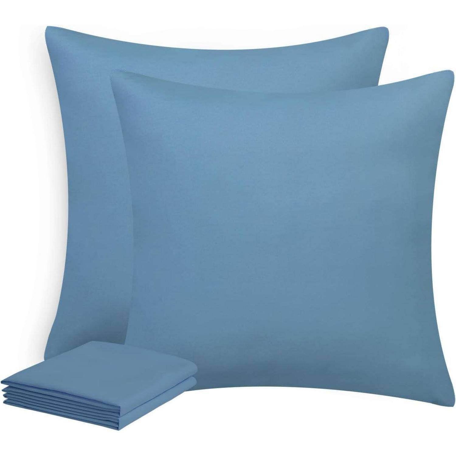Zwei große blaue quadratische Kissen mit einem Stapel von vier passenden blauen Kissenbezügen daneben.