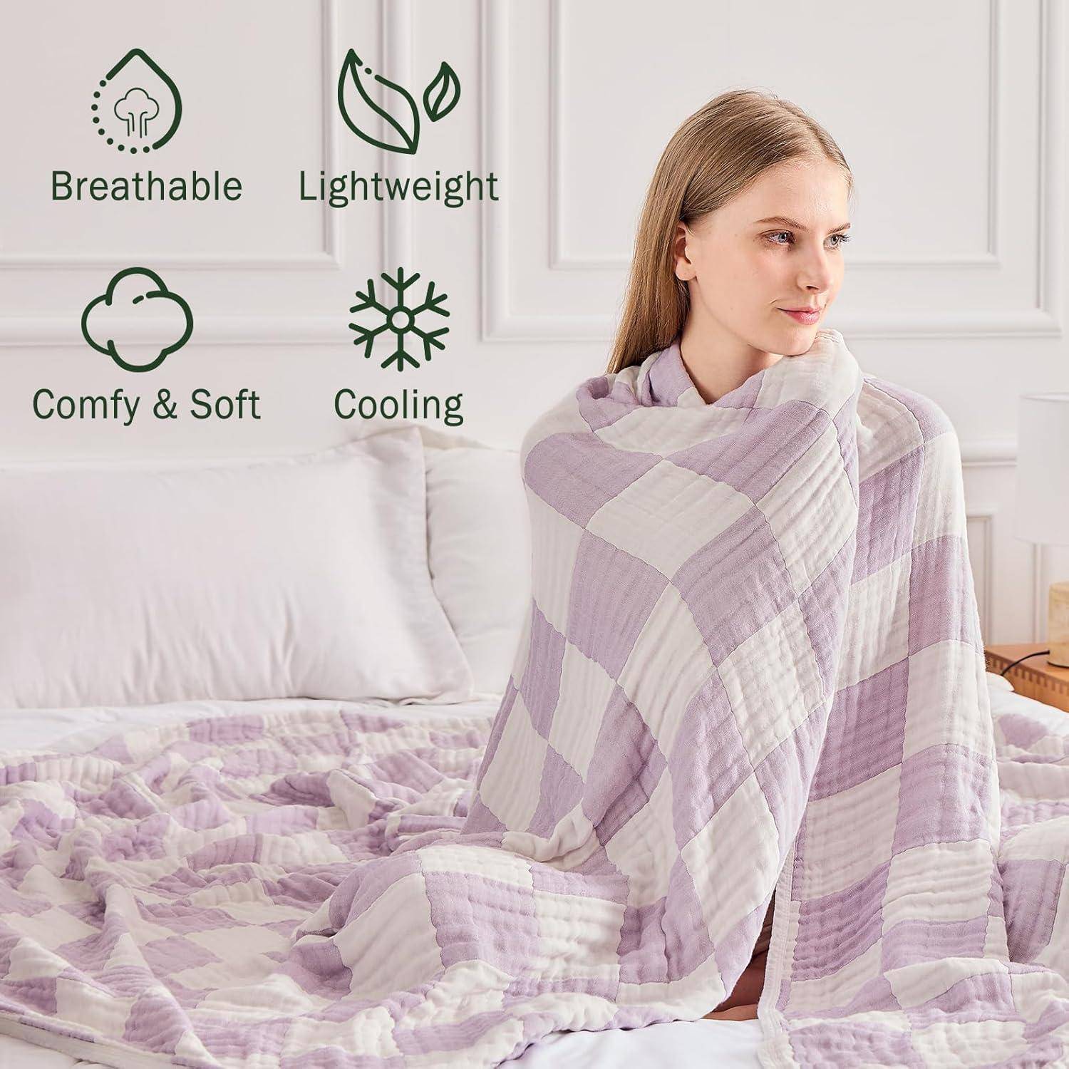Eine Person, die auf einem Bett sitzt und in eine lila karierte Decke gehüllt ist. Symbole und Text zeigen, dass die Decke 