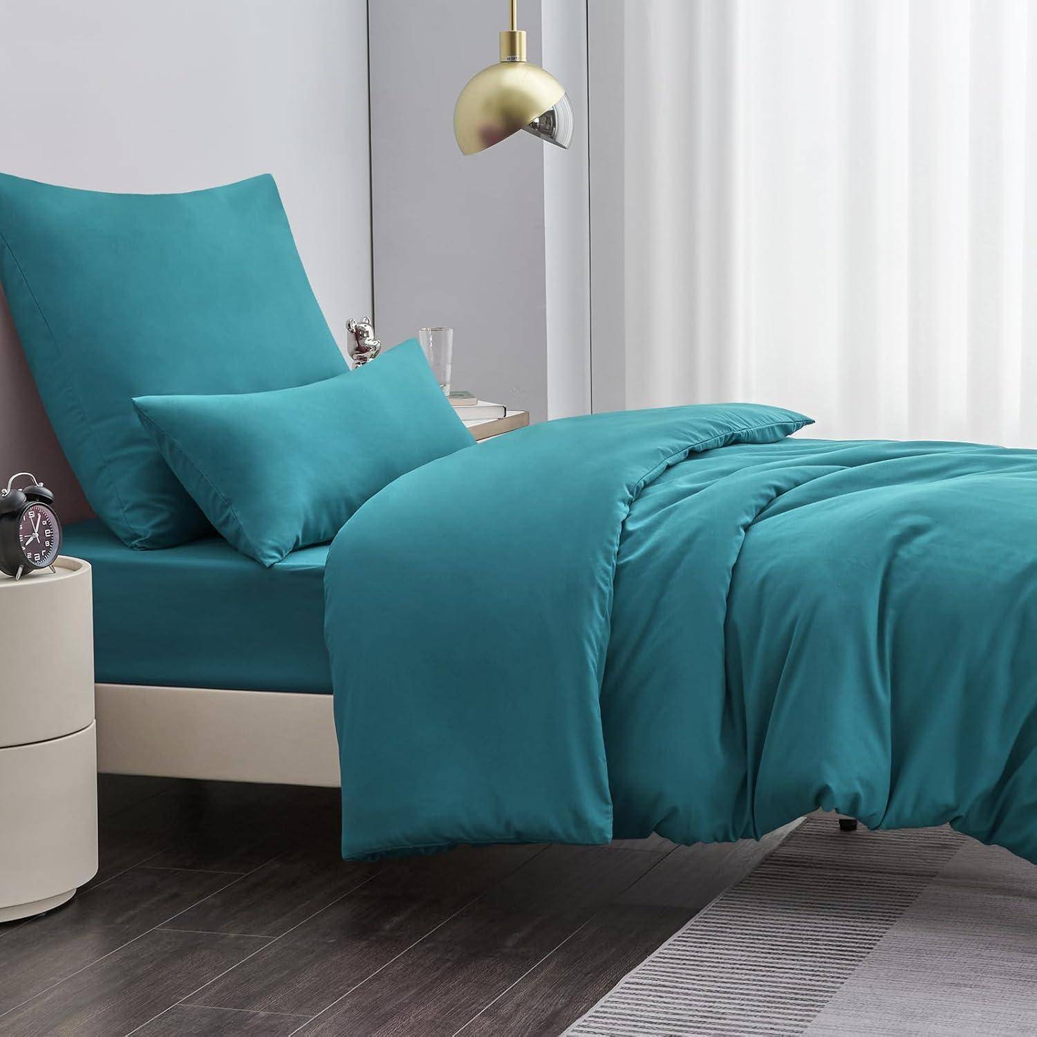 Petrol-blaue Bettwäsche mit Kissen auf einem modernen Bett. Ein Nachttisch mit einer Lampe steht in der Nähe und schafft eine gemütliche, zeitgenössische Schlafzimmeratmosphäre.