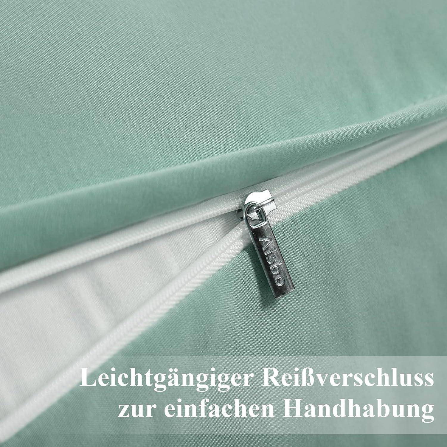 Eine Nahaufnahme eines grünen Kissenbezugs mit einem teilweise geöffneten Reißverschluss; der Text auf Deutsch lautet: „Leichtgängiger Reißverschluss zur einfachen Handhabung.