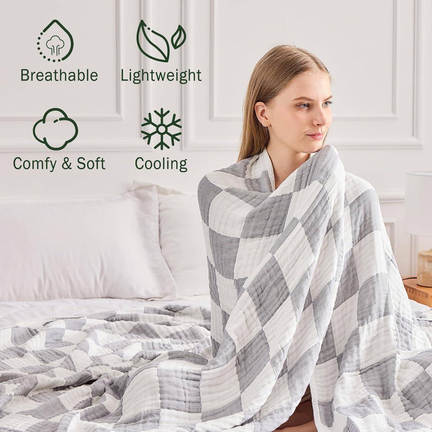 Eine Frau sitzt auf einem Bett, eingehüllt in eine karierte Decke. Symbole deuten darauf hin, dass die Decke „Atmungsaktiv