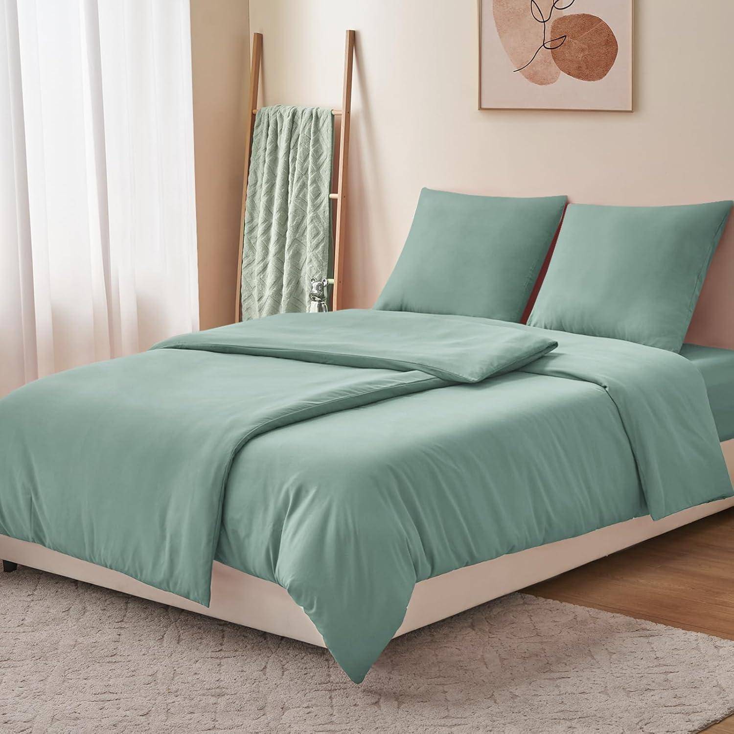 Ein ordentlich gemachtes Bett mit hellturkisfarbener Bettwäsche und passenden Kissen, ein grünes Handtuch, das an einer Leiter hängt, und eine minimalistische Wandkunst.
