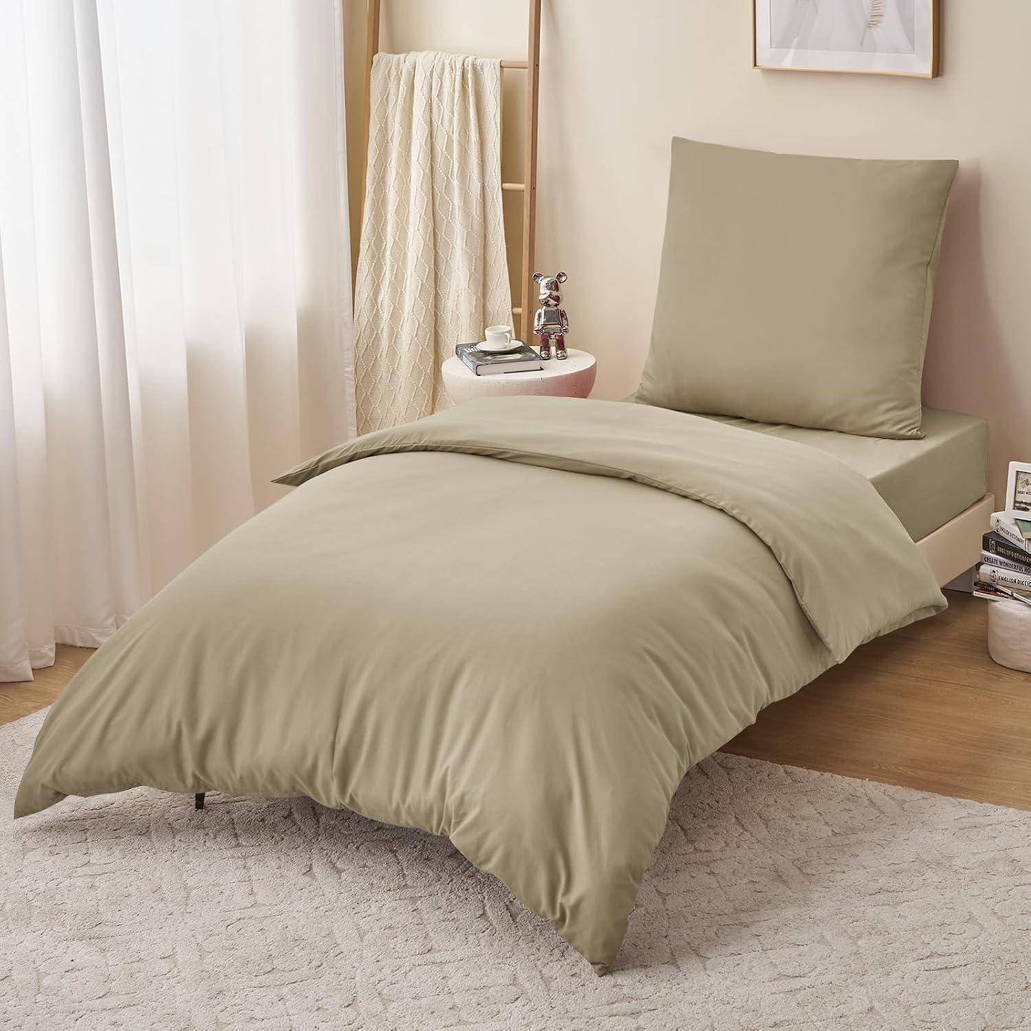 Ein ordentlich gemachtes Bett mit beigefarbener Bettwäsche, einem Kissen und einem gefalteten Handtuch auf einem Stuhl neben einem Nachttisch mit einer silbernen Vase und weißer Dekoration.