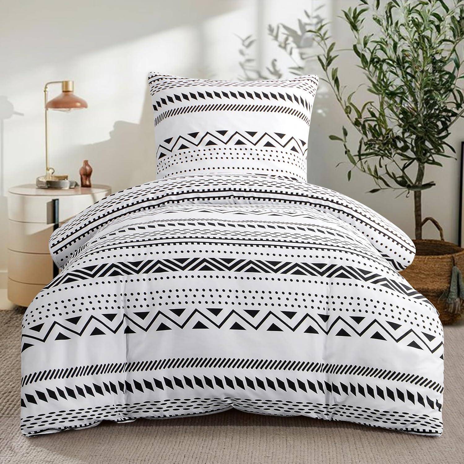 Schwarz-weiß gemusterte geometrische Bettwäsche auf einem Bett in einem modernen Schlafzimmer mit einer Topfpflanze und einem minimalistischen Nachttisch mit einer Lampe.