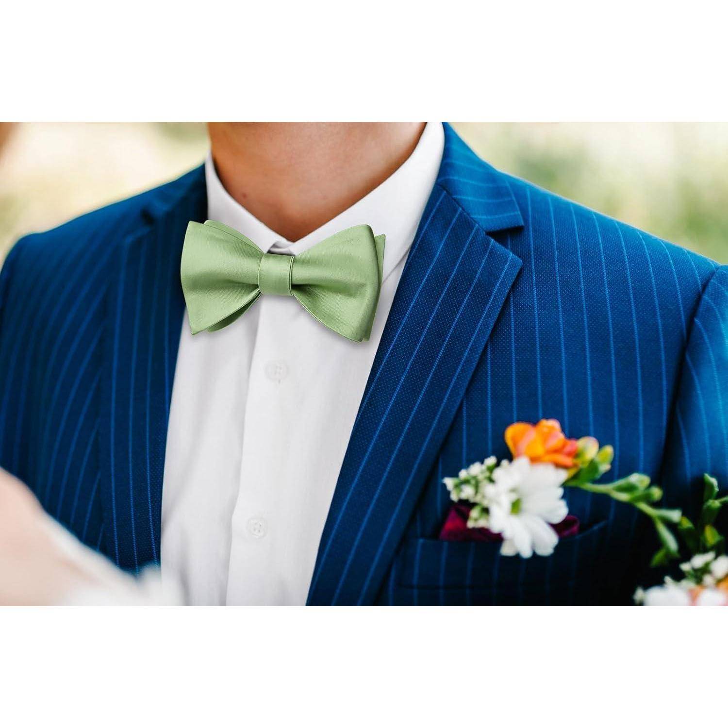 Eine Person in einem blauen Nadelstreifenanzug mit einer grünen Fliege und einer bunten Ansteckblume aus weißen, lila und orangefarbenen Blumen auf dem Revers.
