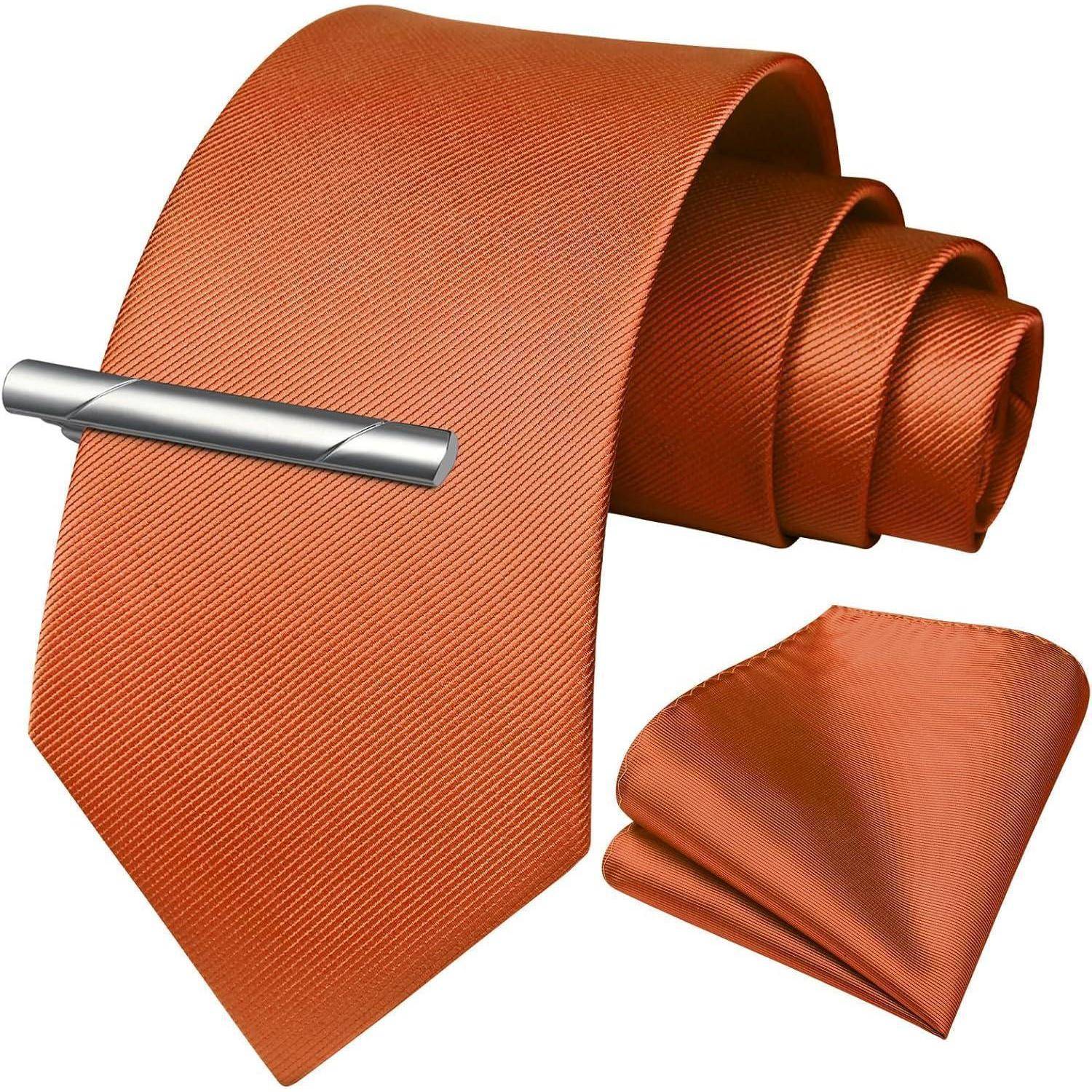 Orange-seidene Krawatte mit einer Krawattennadel, kombiniert mit dem passenden Einstecktuch.