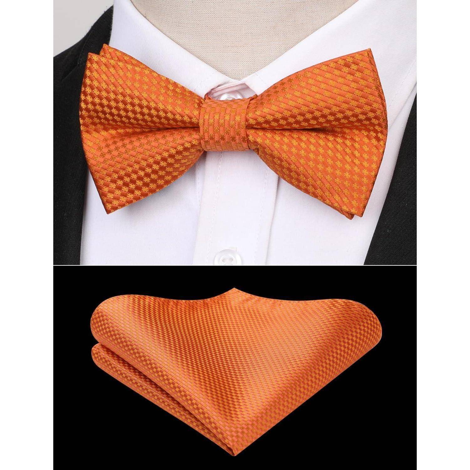 Eine orange karierte Fliege und ein passendes Einstecktuch auf einem weißen Hemd und einer schwarzen Jacke.