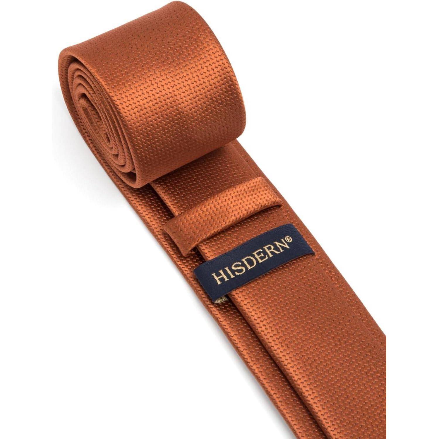 Eine orange Seidenkrawatte aufgerollt, mit dem Etikett 'HISDERN' versehen.