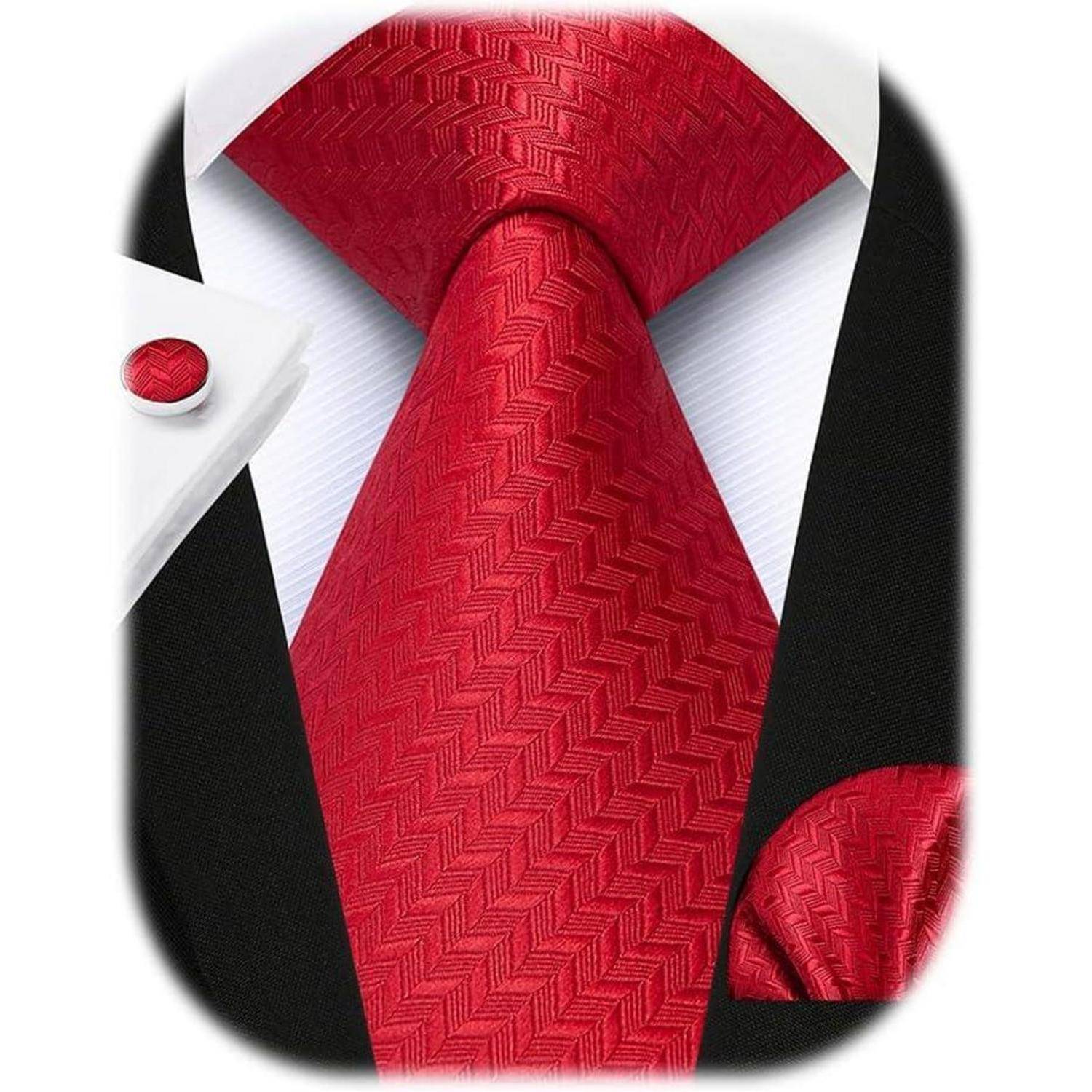 Eine rote gemusterte Krawatte, ein passendes Einstecktuch und Manschettenknöpfe mit einem weißen Hemd und einem schwarzen Anzug. Elegante formelle Kleidung präsentiert.