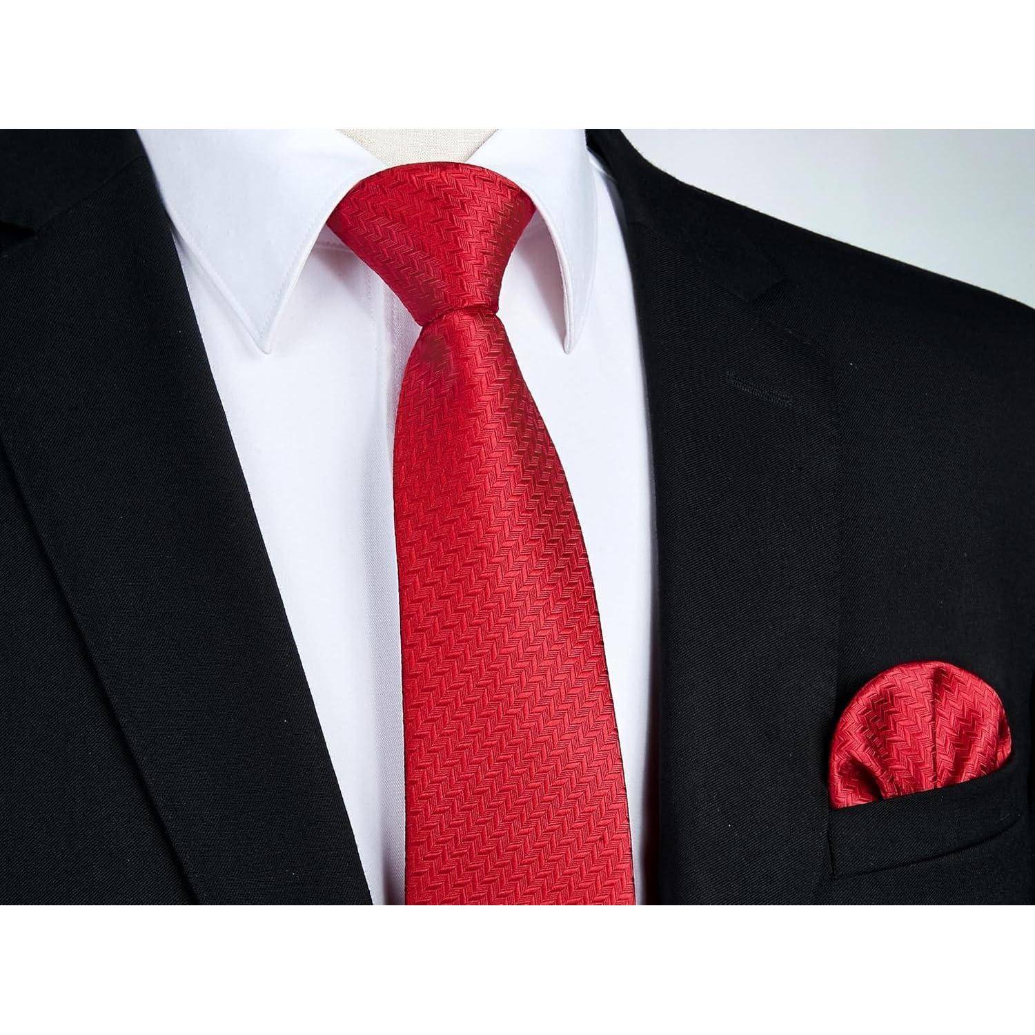 Eine Person, die einen schwarzen Anzug mit einem weißen Hemd, einer roten Krawatte und einem passenden roten Einstecktuch trägt und einen formellen und eleganten Stil zur Schau stellt.