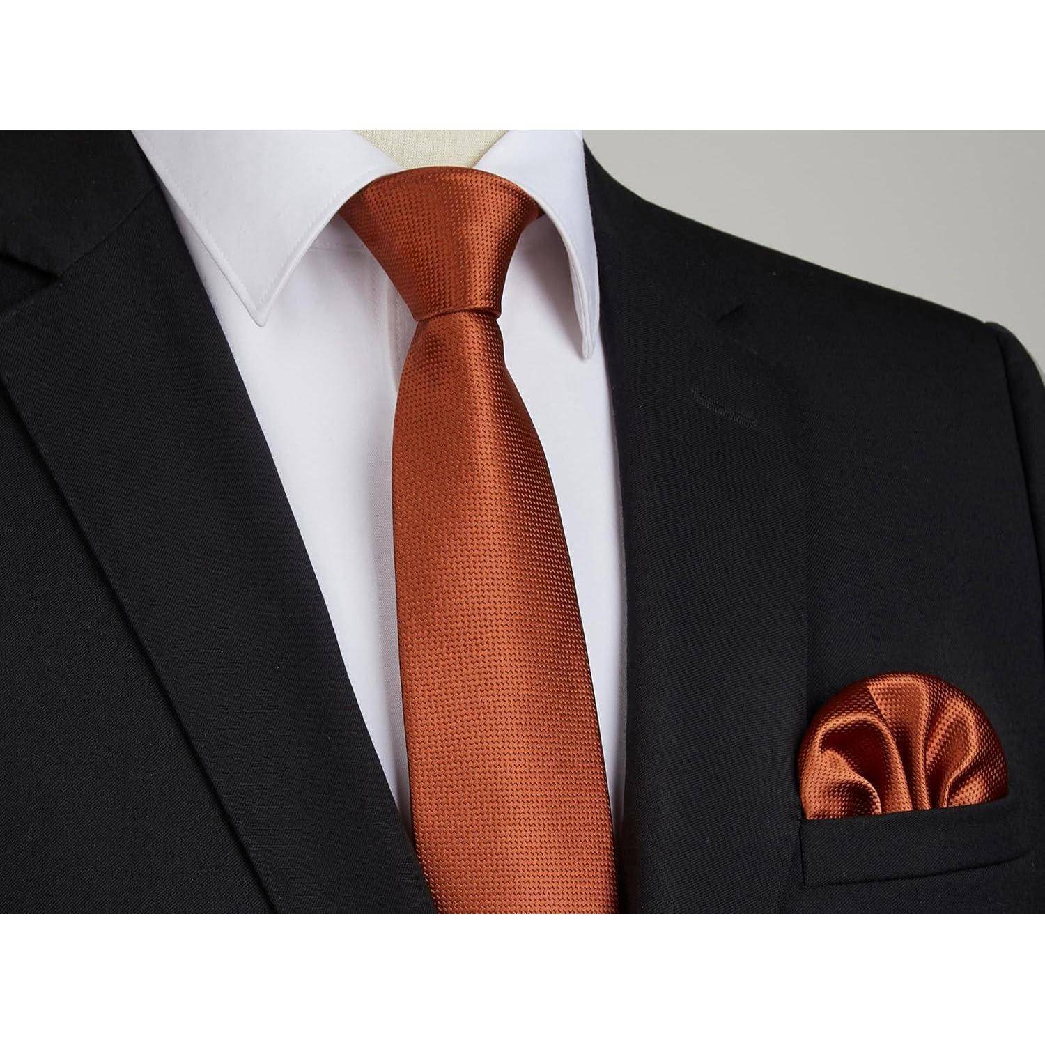 Eine Nahaufnahme eines schwarzen Anzugsjackets mit einem weißen Hemd und einer orangefarbenen Krawatte. Das Einstecktuch passt zur Krawatte und vervollständigt den formellen Look.