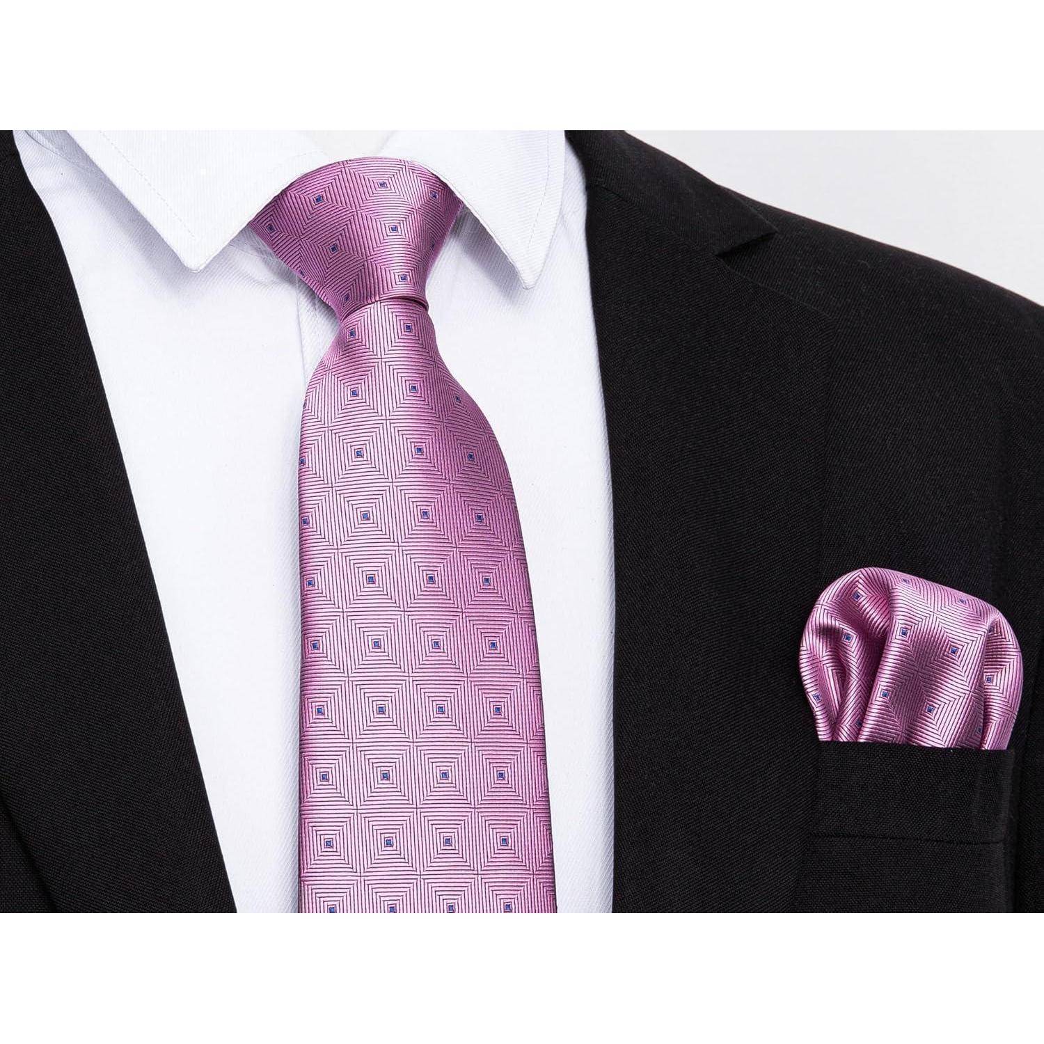 Eine Person in einem schwarzen Anzug mit weißem Hemd, die eine gemusterte rosa Krawatte und ein passendes rosa Einstecktuch trägt.