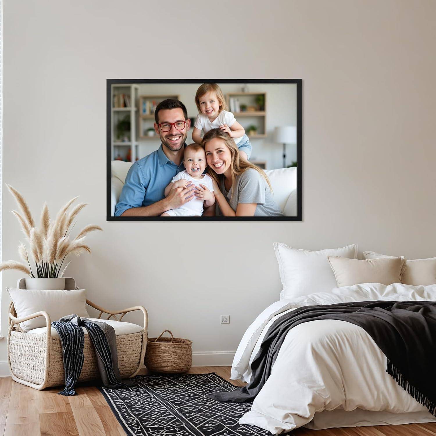 Ein gerahmtes Foto an einer beigen Wand zeigt eine lächelnde Familie von vier Personen - zwei Erwachsene, ein Kind und ein Baby - die zusammen auf einem Sofa posieren.