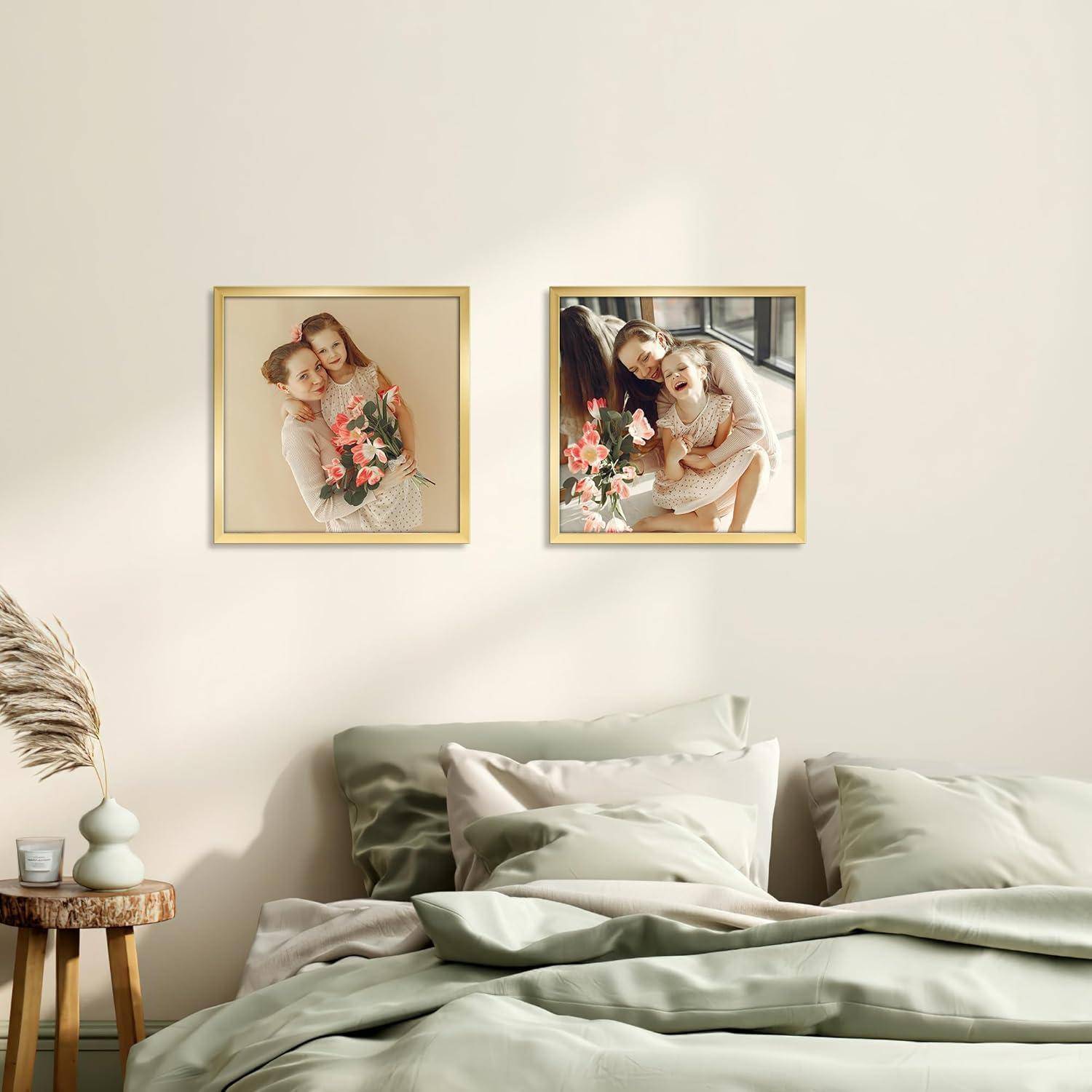 Zwei gerahmte Fotos einer Frau und eines Kindes mit Blumen sind über einem Bett mit Kissen an einer beigen Wand aufgehängt.