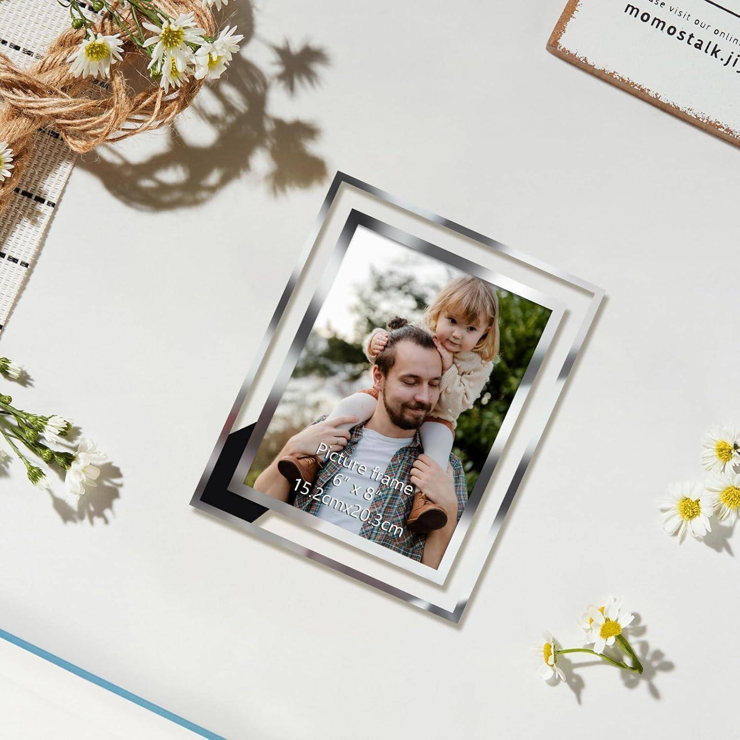 Ein Fotorahmen mit einem Bild einer Person, die ein Kind auf den Schultern trägt, steht auf einem Tisch mit Gänseblümchen und einem Notizblock in der Nähe.