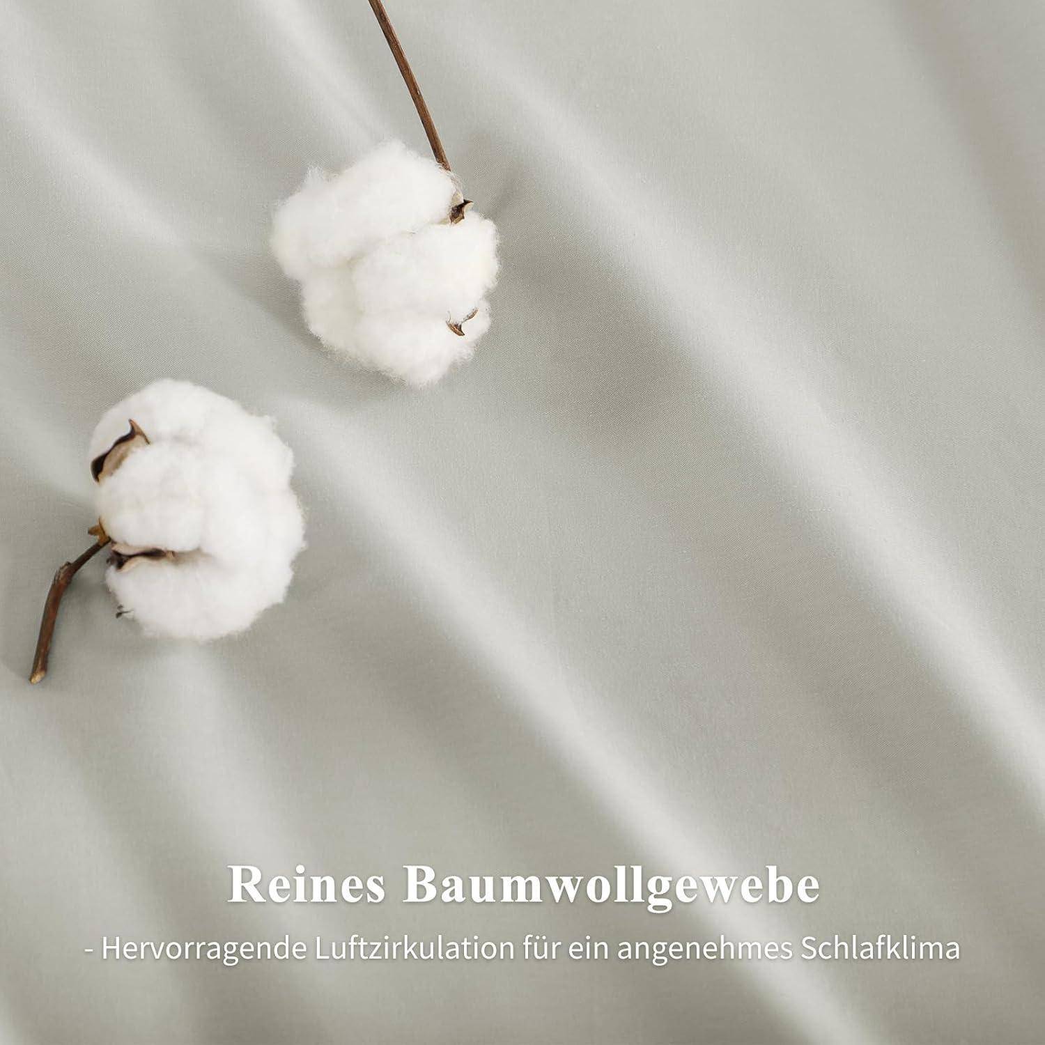 Zwei Baumwollblüten auf einer hellgrauen Gewebeoberfläche. Text lautet: Reines Baumwollgewebe - Hervorragende Luftzirkulation für ein angenehmes Schlafklima.