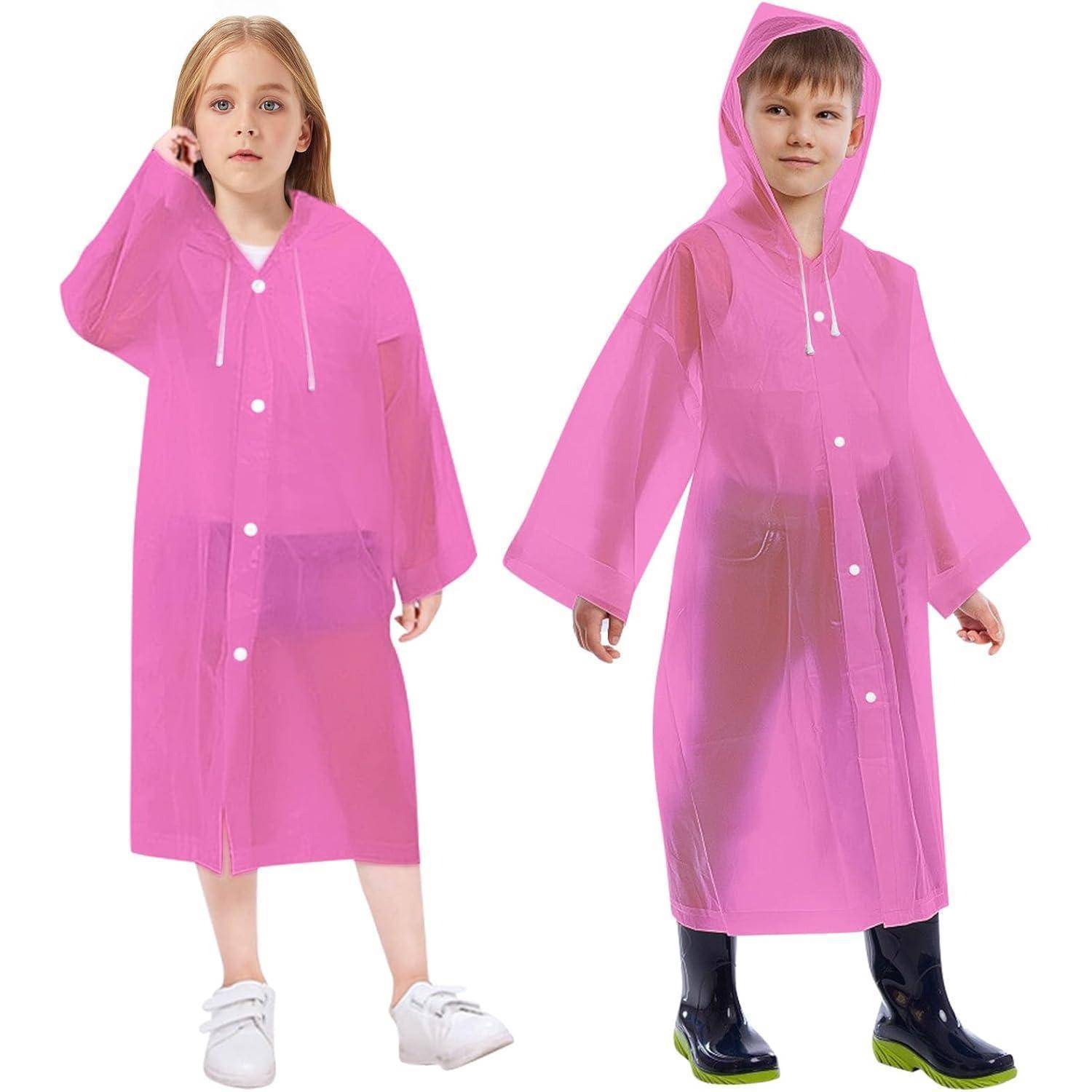 Ein junges Mädchen und ein Junge tragen rosa Regenmäntel und stehen. Der Junge hat die Kapuze auf und trägt schwarze Stiefel.